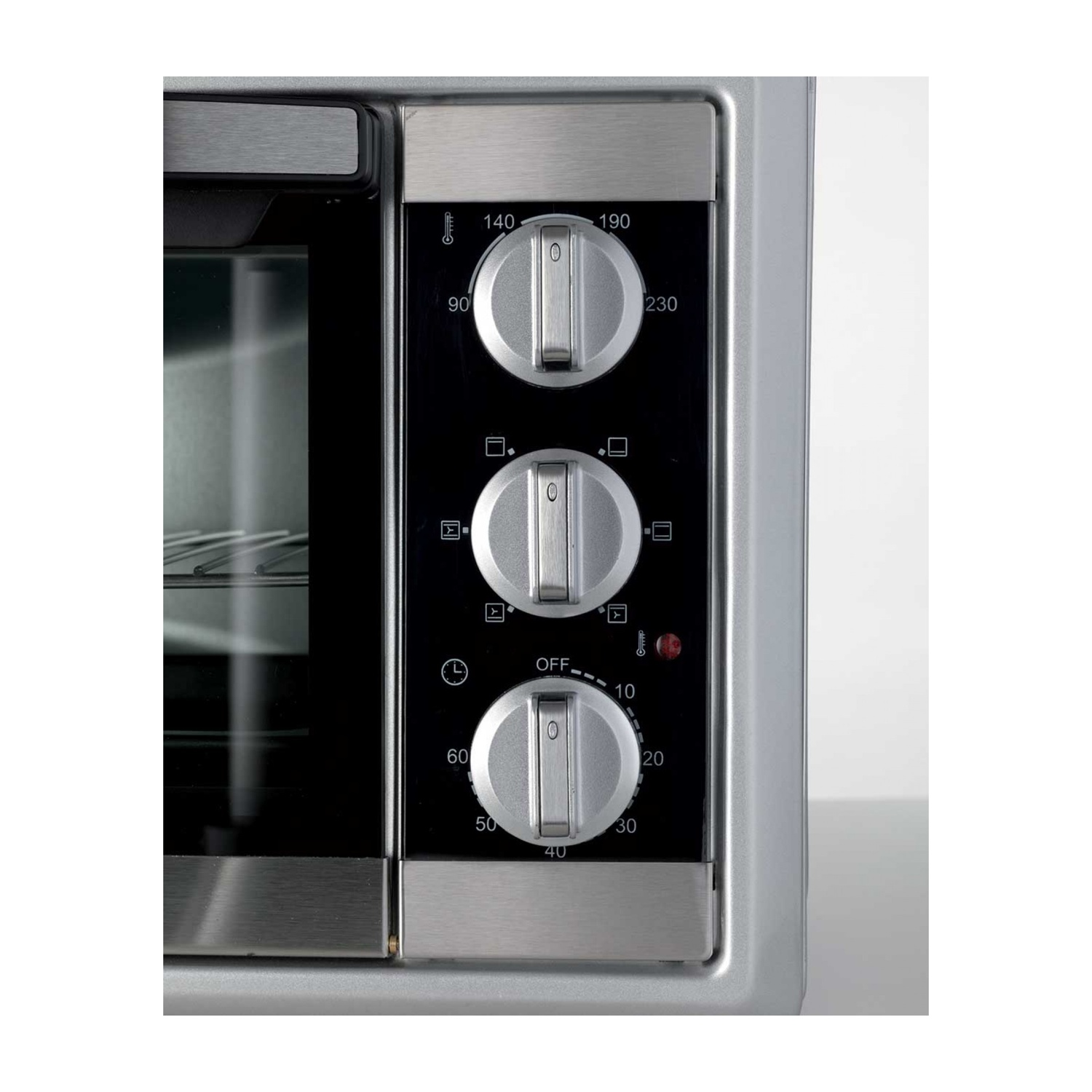 Pannello comandi forno con manopole per temperatura, funzione e timer, su forno argentato.