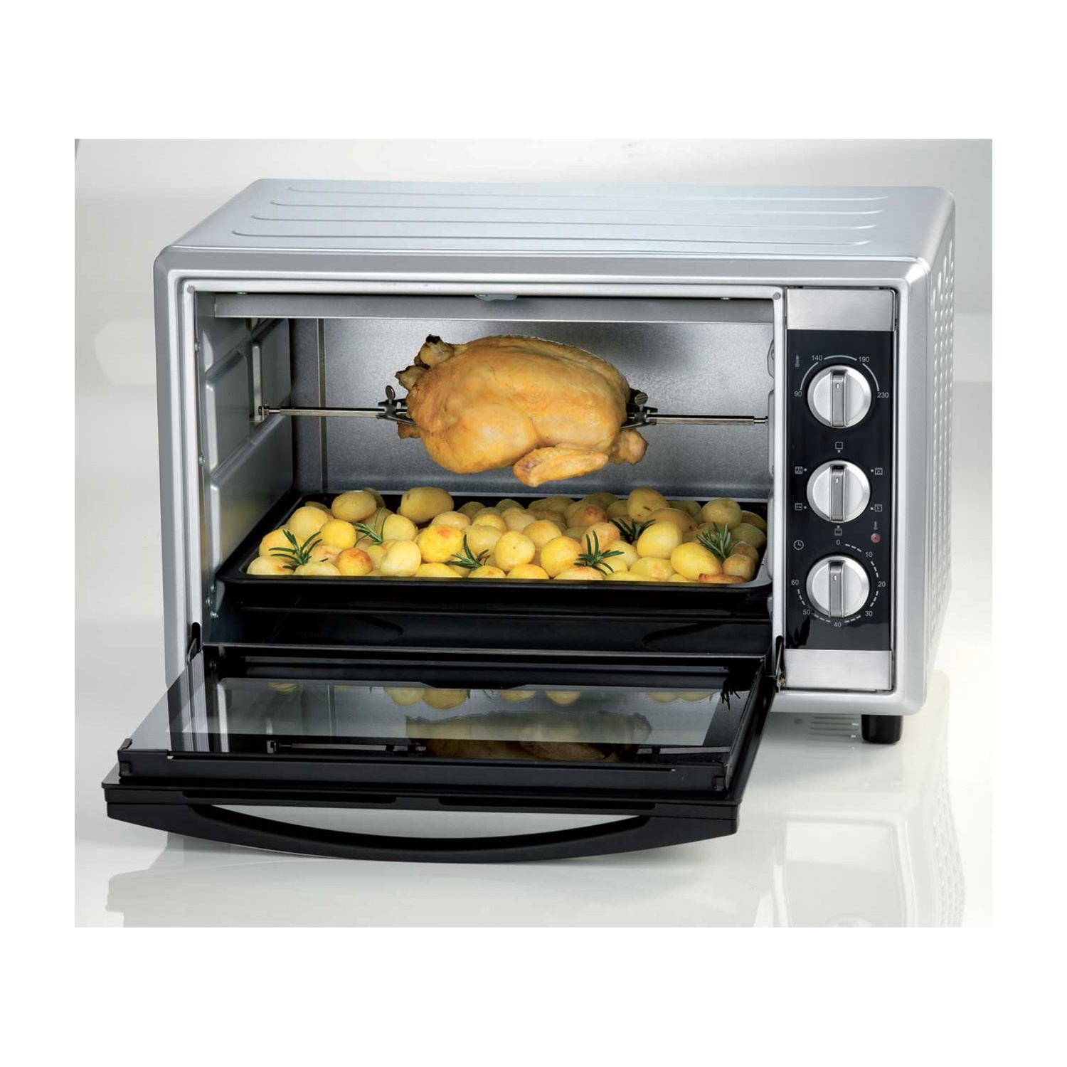 Forno argento e nero con pollo allo spiedo, patate e porta a vetro.