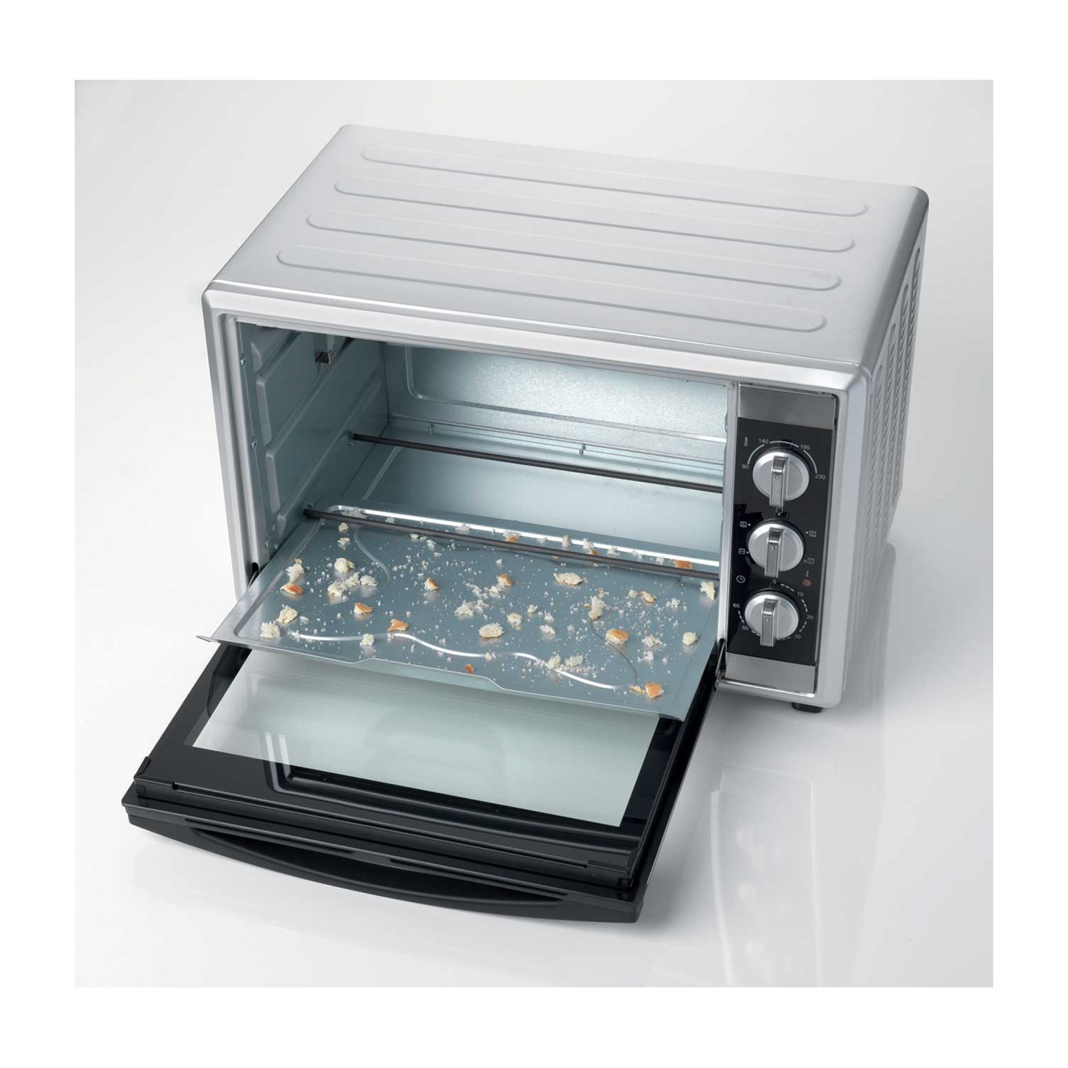 Forno argentato con la porta aperta. Pezzi di pane sul vassoio all'interno.
