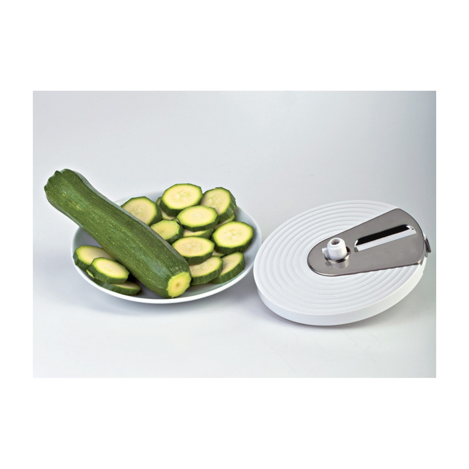 Zucchine e fette di zucchine in una ciotola accanto a uno spiralizzatore.