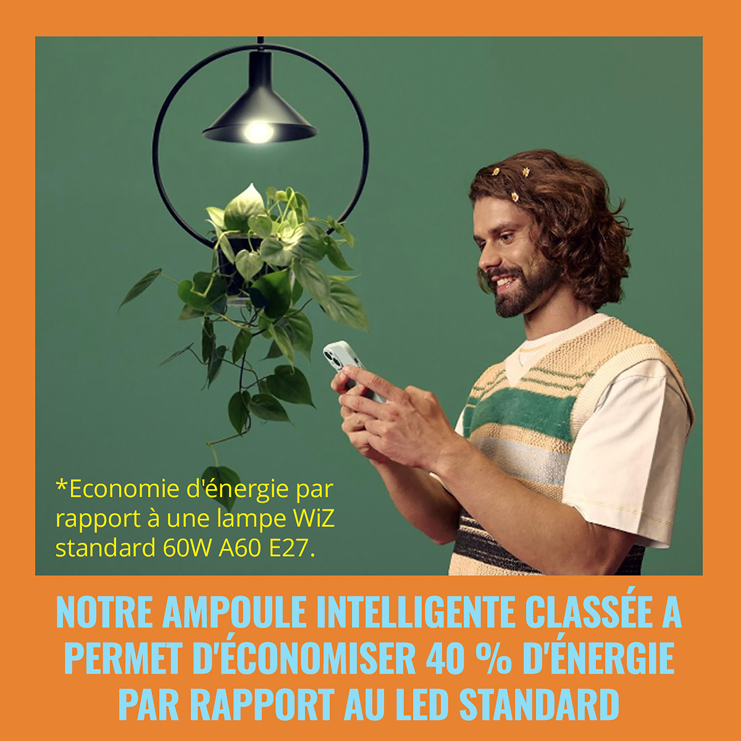 Un homme sourit à un smartphone tout en étant sous un luminaire suspendu.