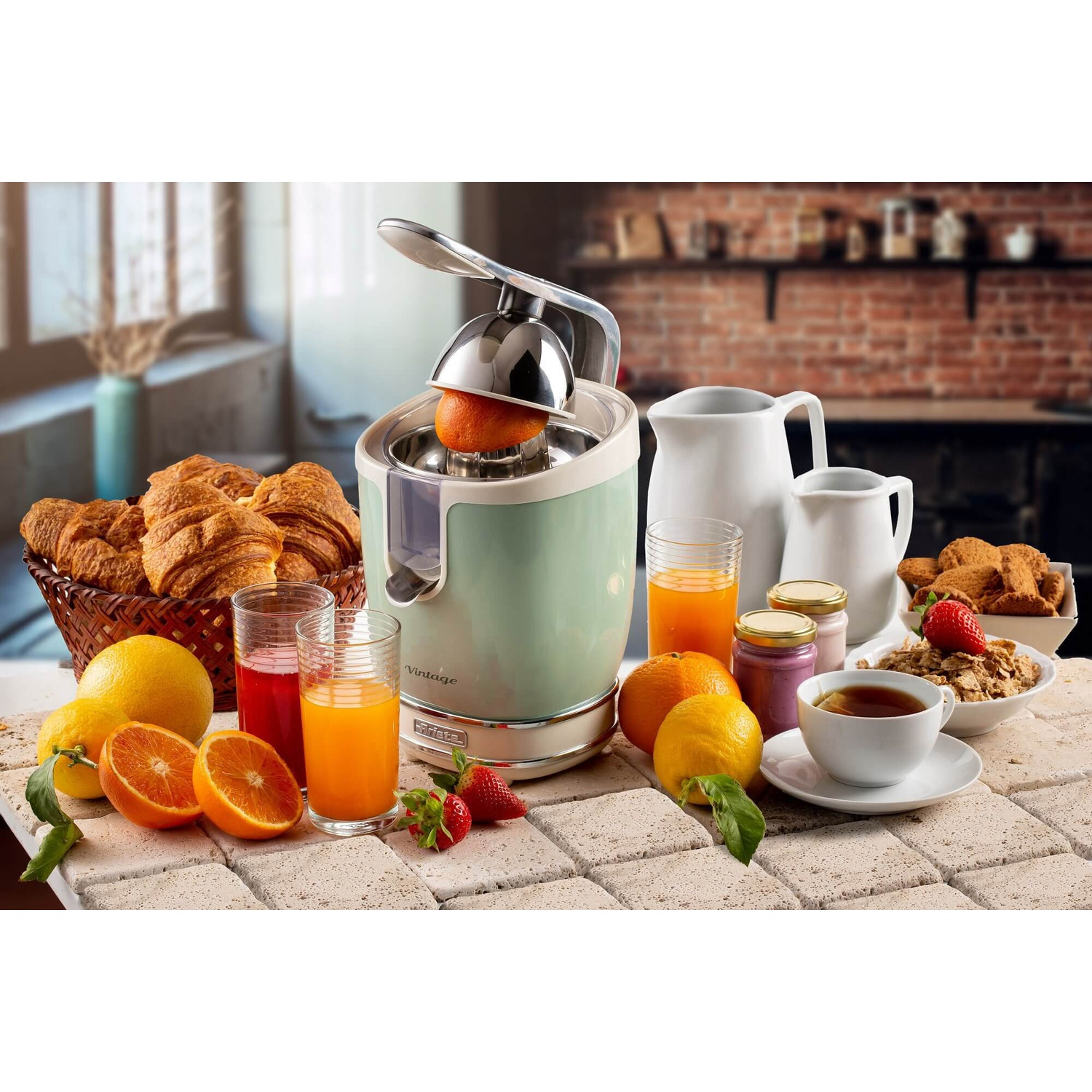 Scena della cucina con spremiagrumi, frutta, bicchieri di succo e pasticcini.