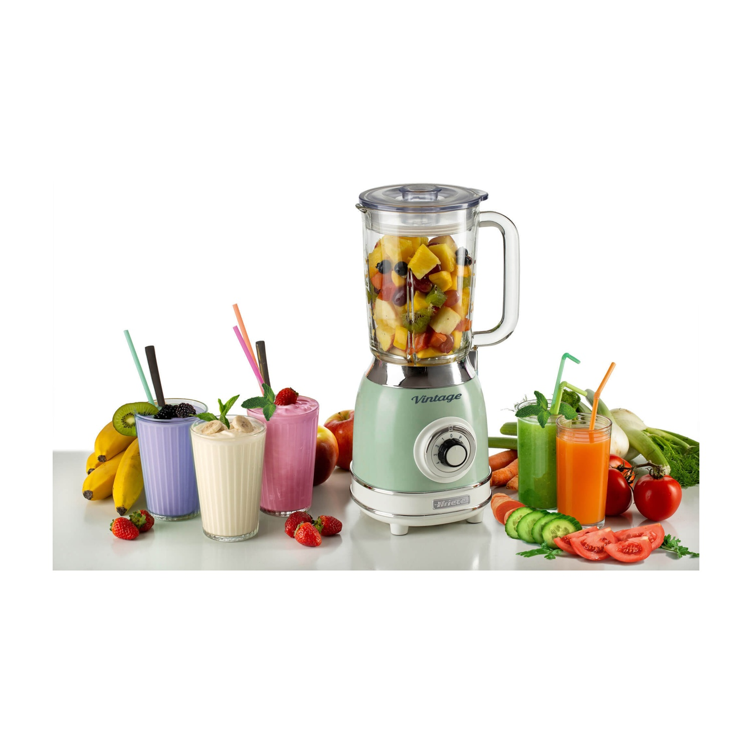 Frullatore con frutta, frullati in bicchieri, frutta sul tavolo.