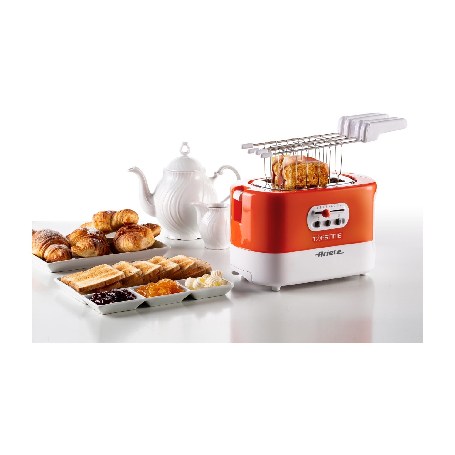 Un tostapane con toast che escono. Un piatto di croissant e pane con marmellata e burro. Una teiera.