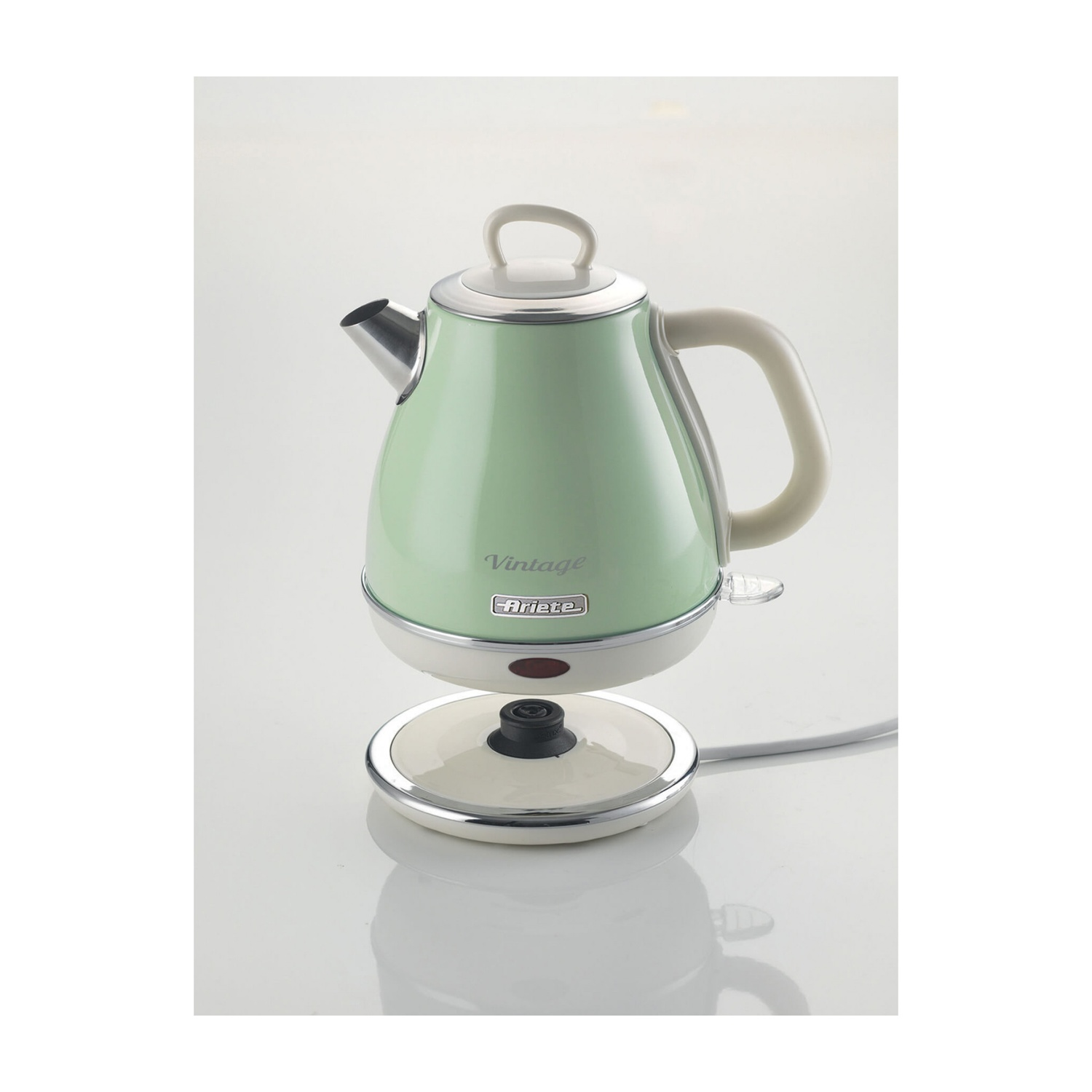 Un bollitore elettrico vintage verde menta, staccato dalla base, su sfondo bianco.