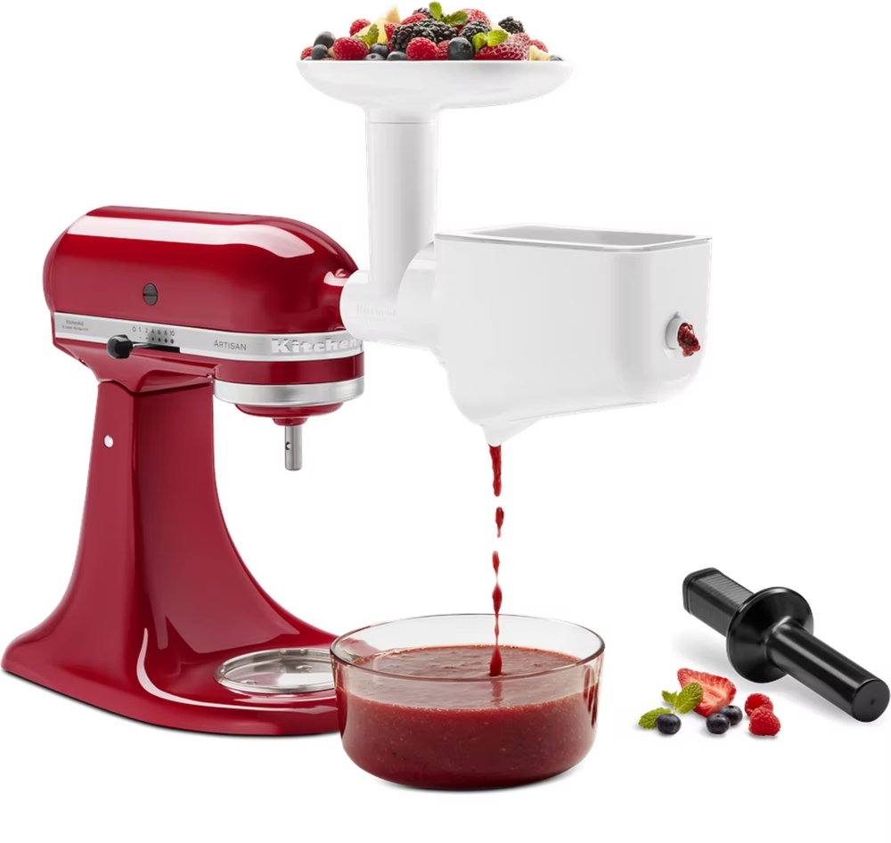 Robot da cucina KitchenAid con accessorio spremiagrumi, una ciotola con bacche e succo.