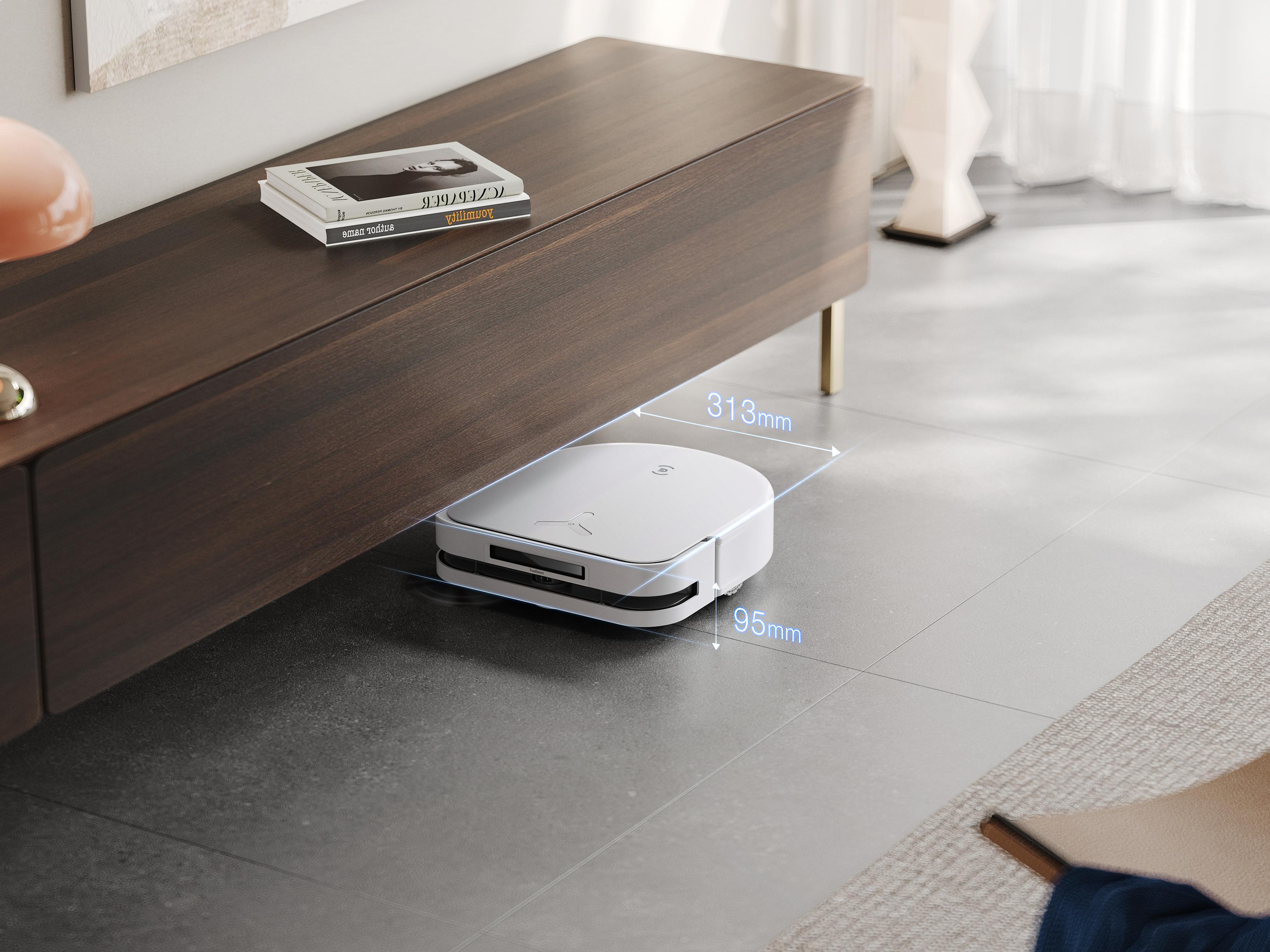 Weißer Roboter-Staubsauger unter einem braunen Schrank. Grauer Boden. Text mit Abmessungen.