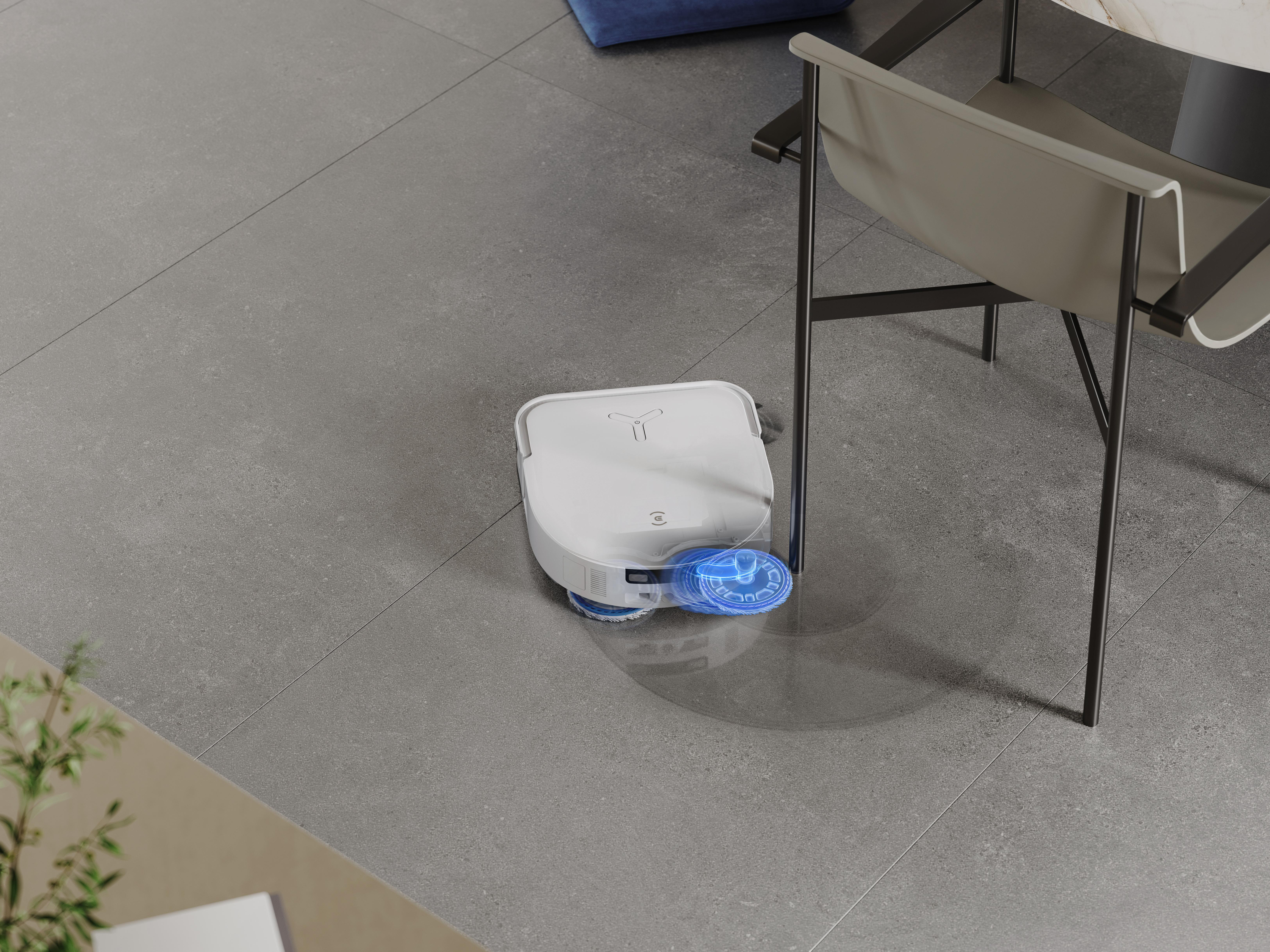 Ein weißer Roboter-Staubsauger auf einem grauen Fliesenboden.