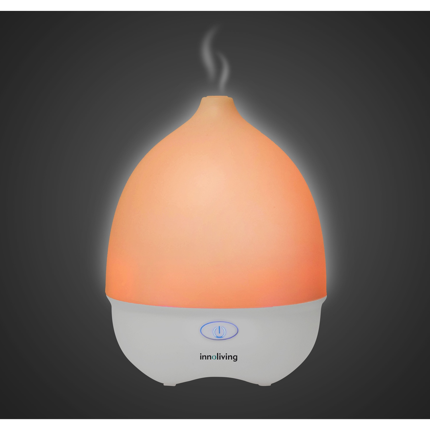 Diffusore di oli essenziali bianco e arancione che emette vapore su sfondo scuro.