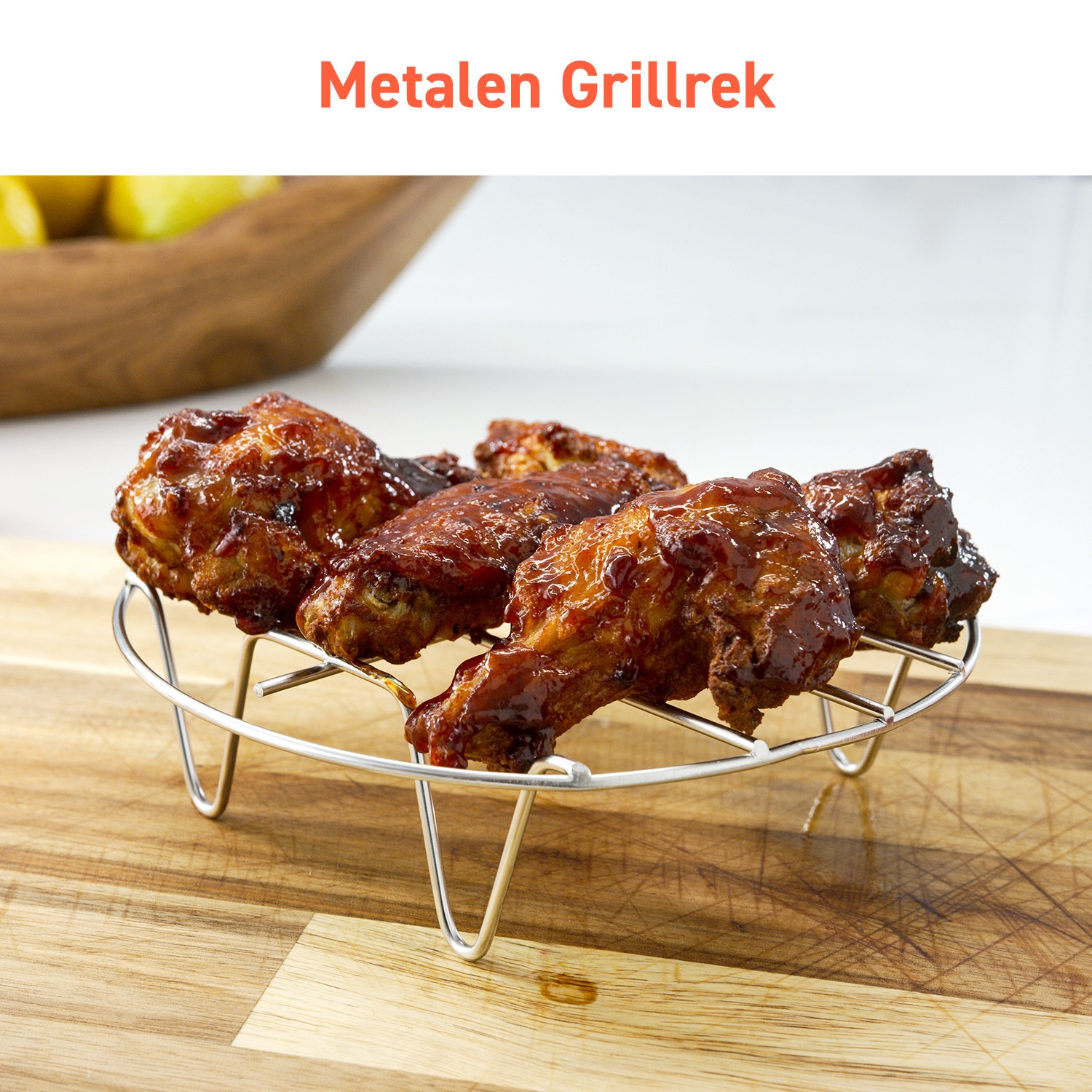 A metal grill rack with cooked chicken wings, on a wooden cutting board.