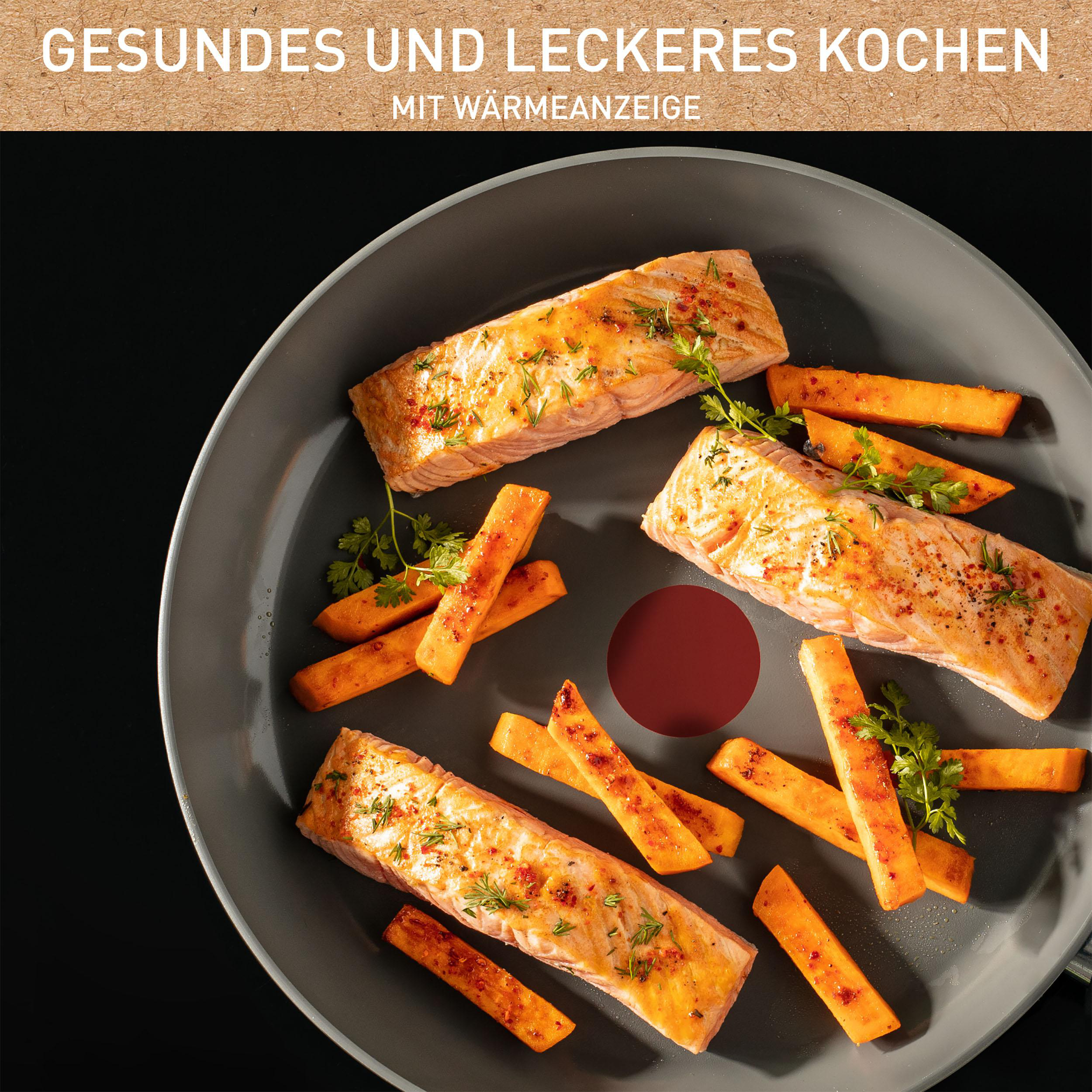 Lachs und Süßkartoffel-Pommes in einer Pfanne, mit Kräutern.