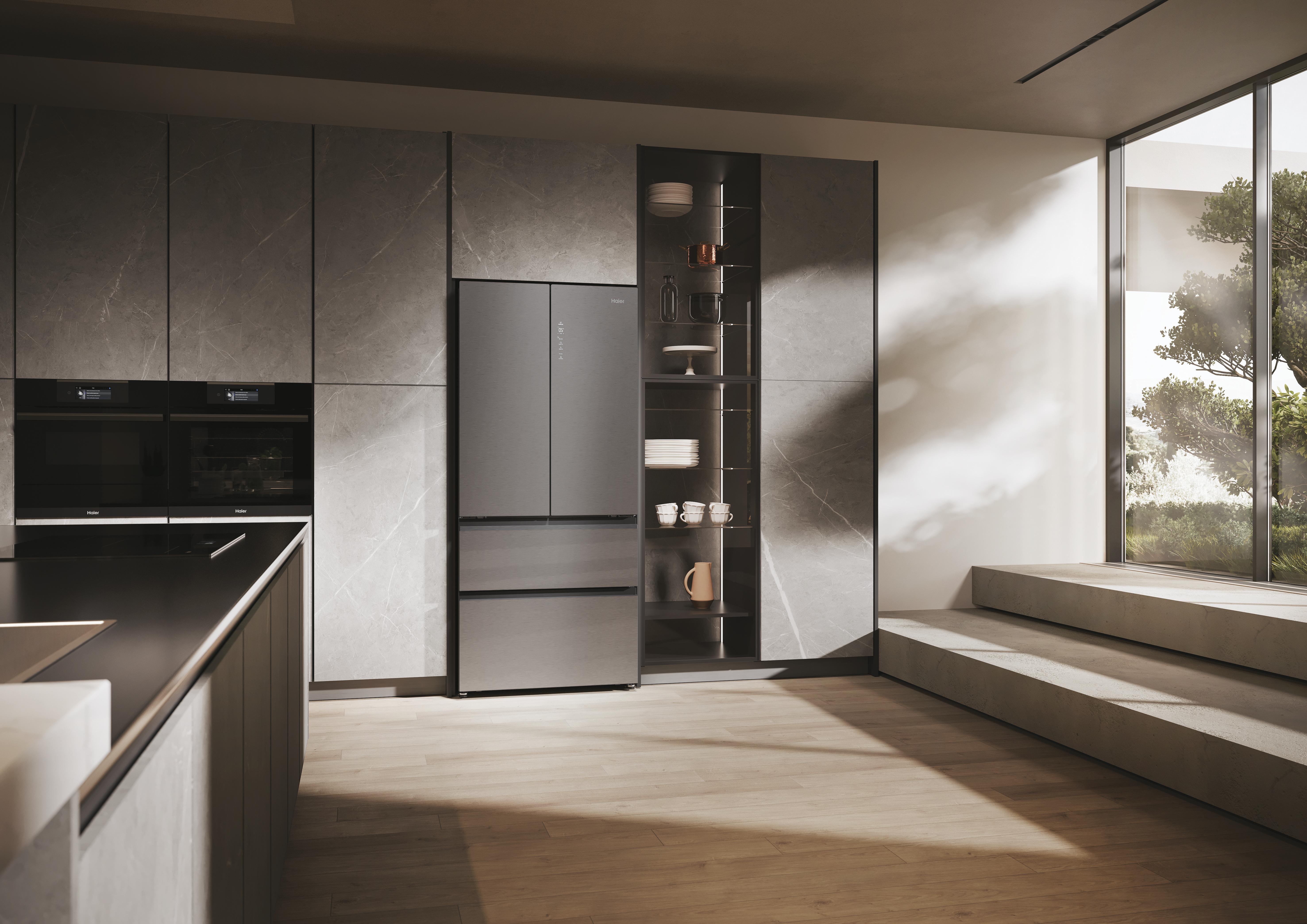 Eine moderne Küche mit Kühlschrank und Einbaugeräten. Die Einrichtung ist grau, mit Holzboden.
