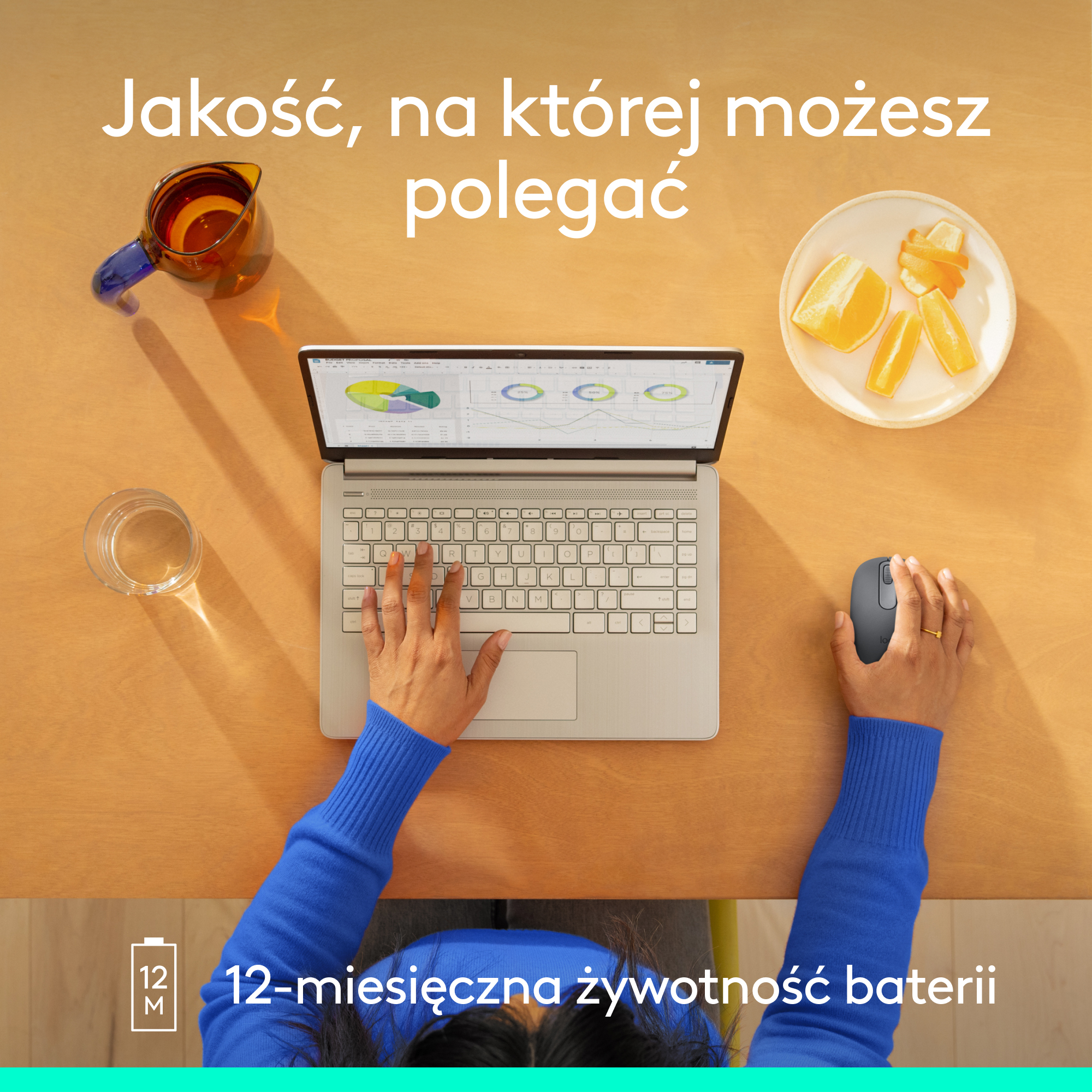 Osoba używa laptopa z myszą na drewnianym stole. W pobliżu jest sok pomarańczowy i szklanka wody.