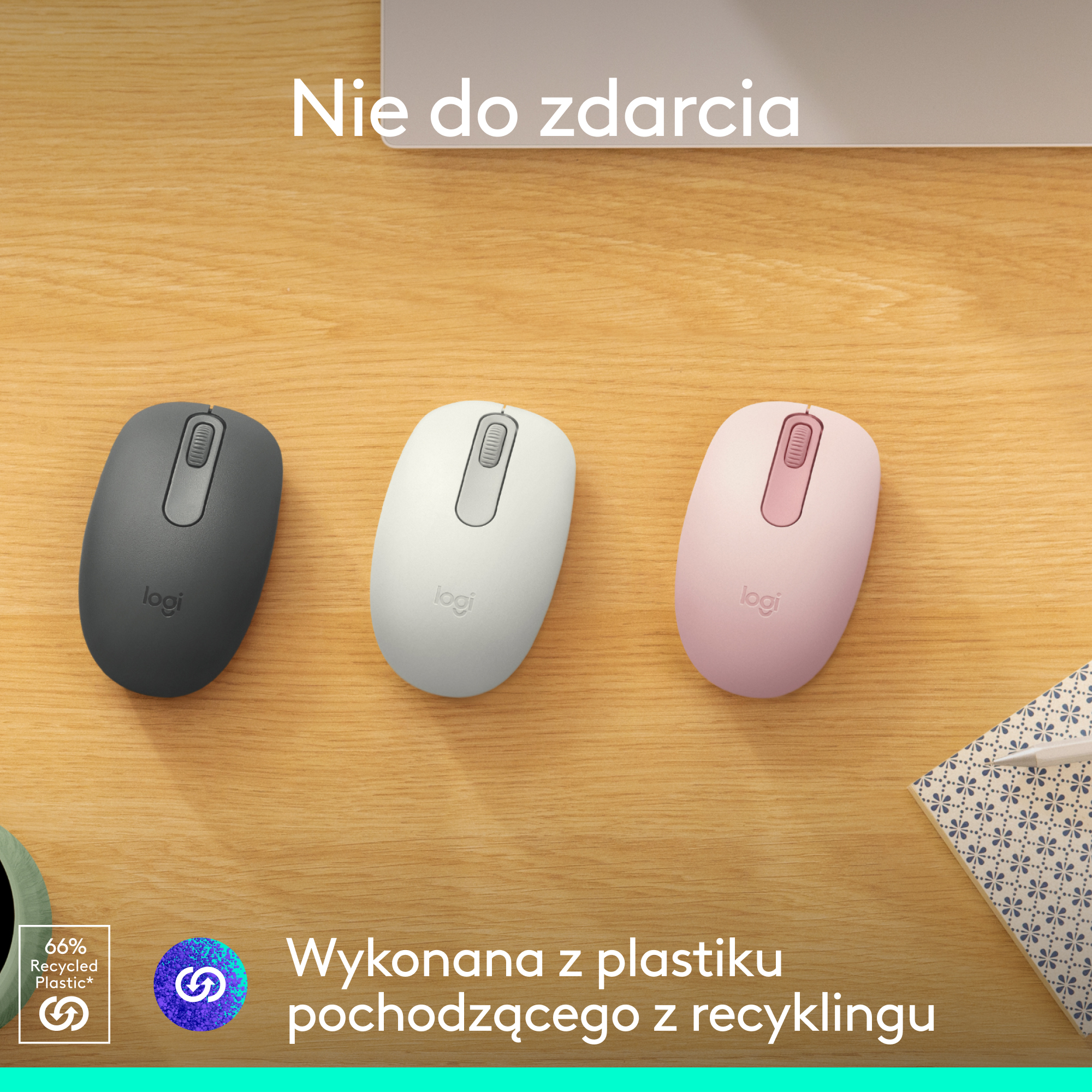 Trzy myszy komputerowe w różnych kolorach. Szary, biały i różowy. Leżą na drewnianym biurku.