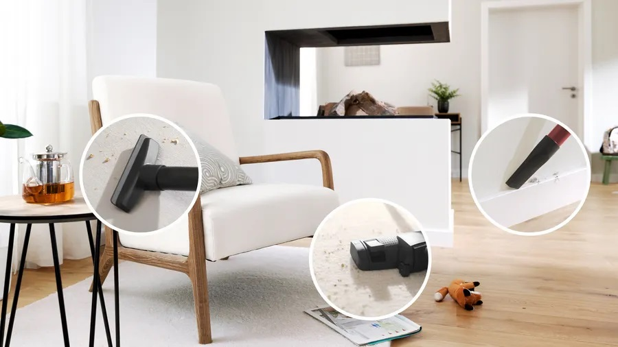 Pokój z białym fotelem, przystawkami do odkurzacza i imbrykiem na stoliku.