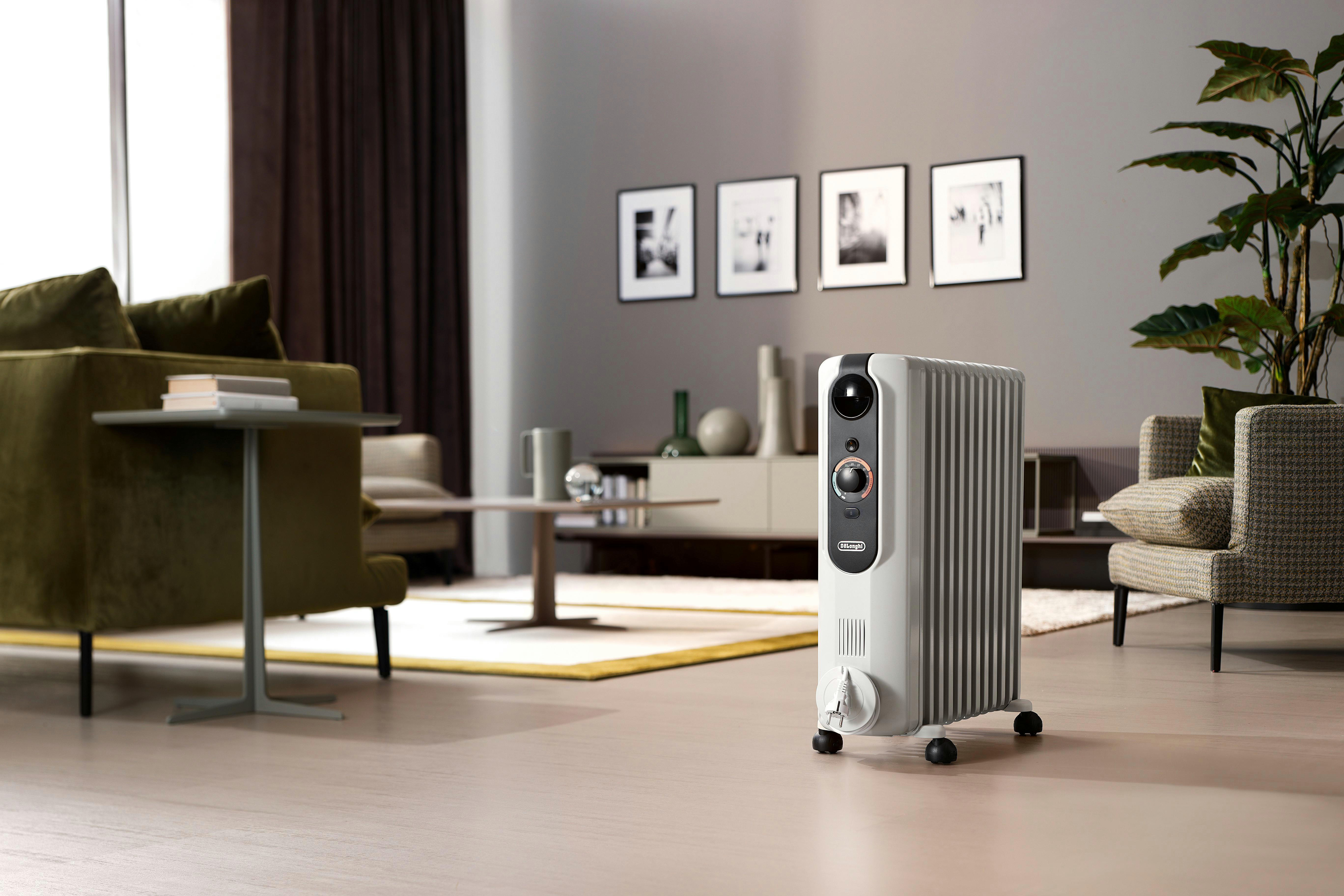 Ein weiß-grauer Ölradiator in einem Wohnzimmer mit modernen Möbeln.