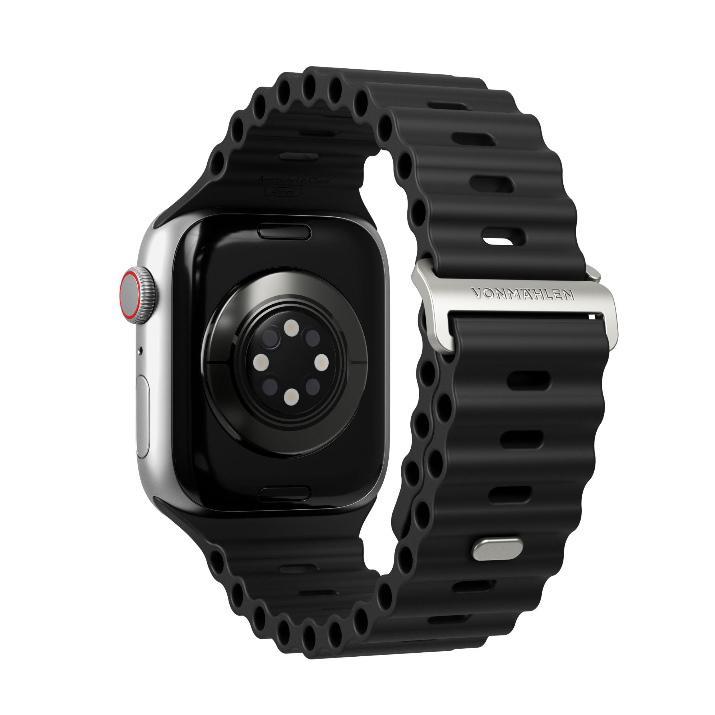 Schwarze Apple Watch mit schwarzem, wellenförmigem Band und silberner Schnalle. Rückseite sichtbar.
