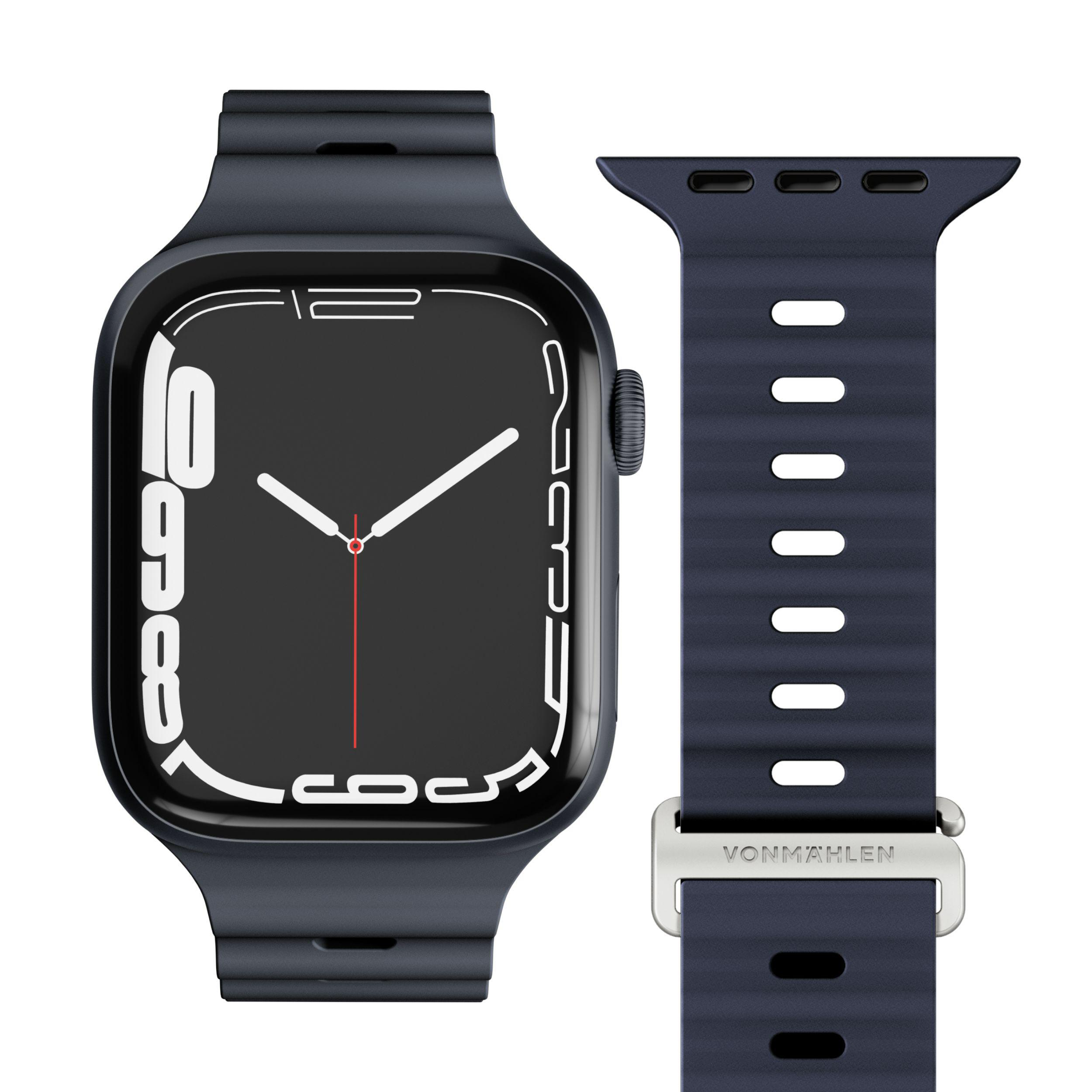 Dunkelblaue Smartwatch mit passendem Armband. Zifferblatt hat weiße Zahlen und Zeiger. Armband hat silberne Schnalle.