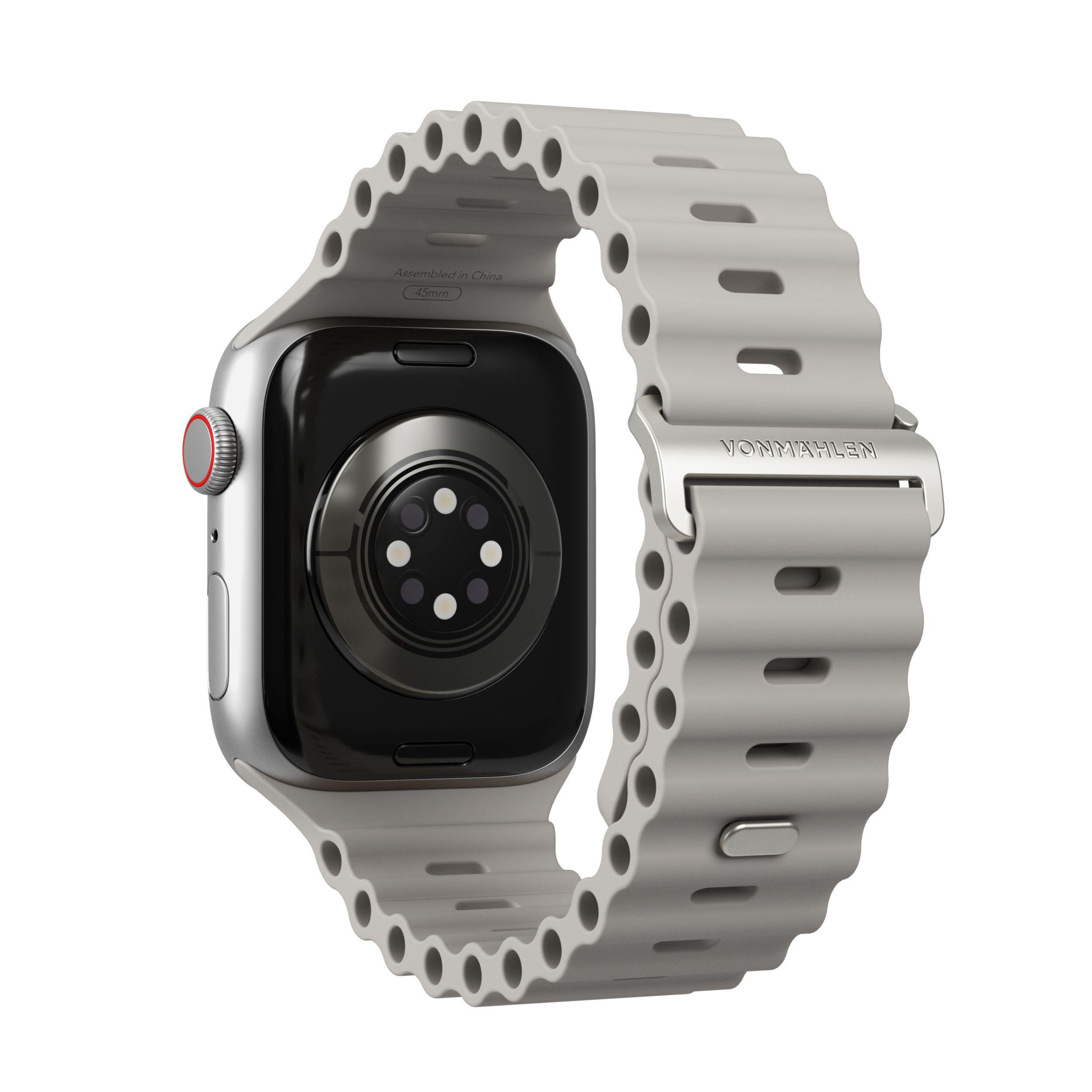 Silberne Apple Watch mit grauem, geriffeltem Armband. Die Rückseite der Uhr ist schwarz. Armband hat Vonmählen-Logo.