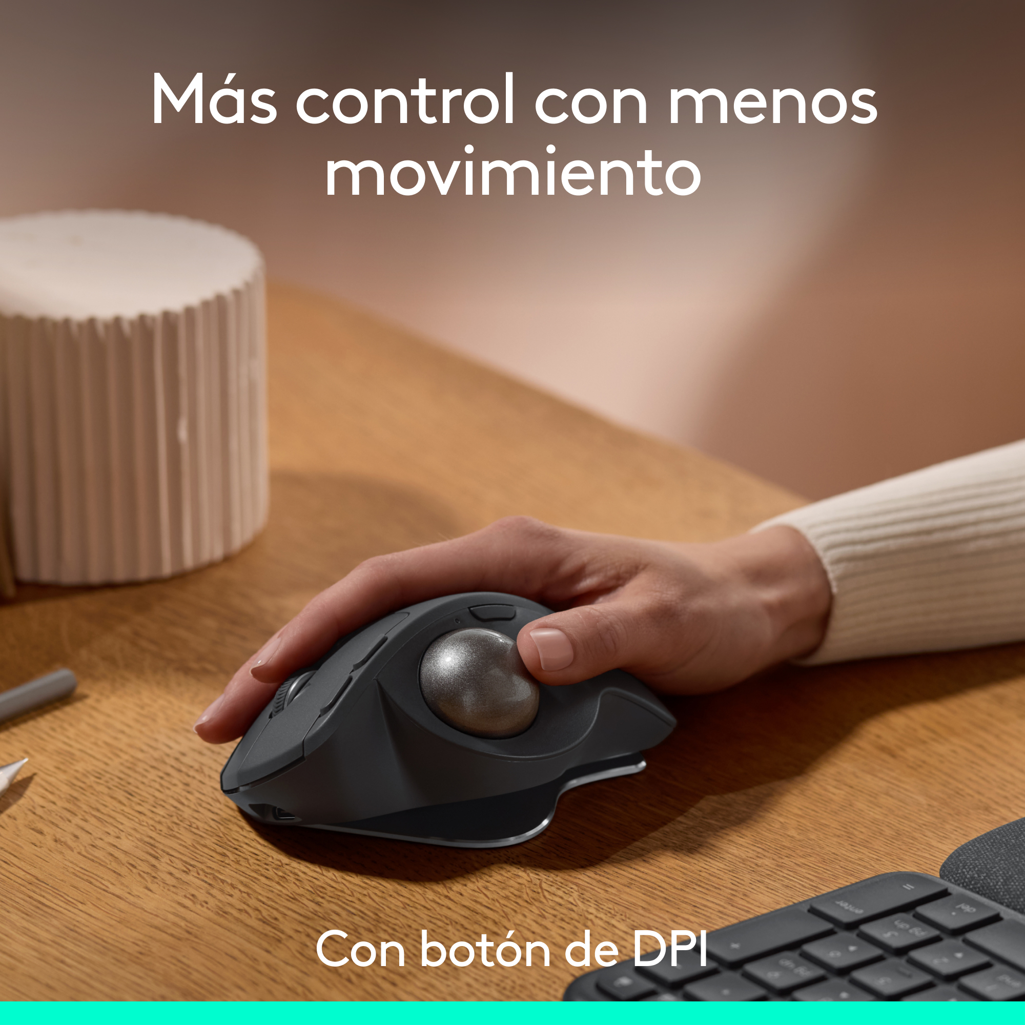 Mano de persona usando un ratón trackball sobre madera.