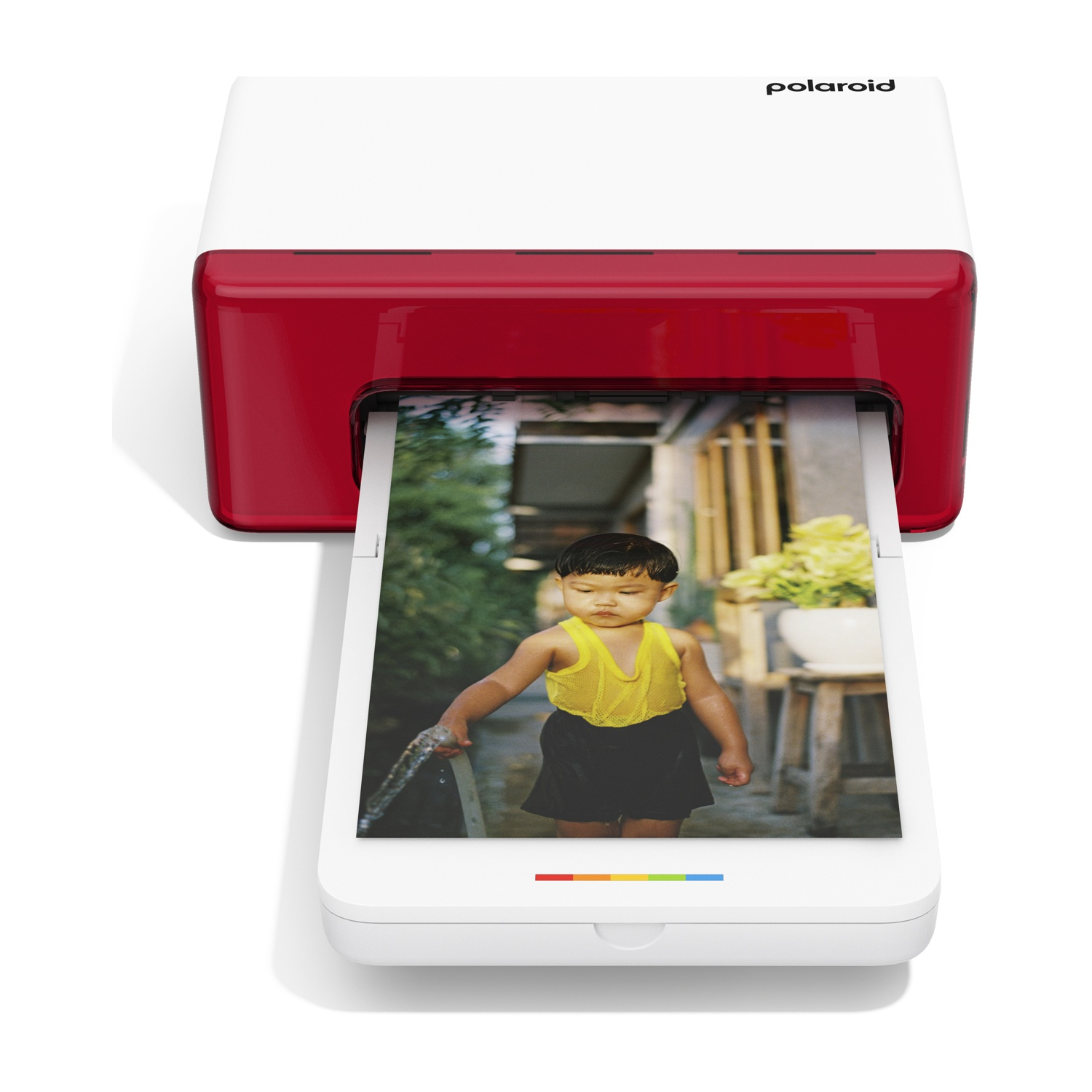 Una stampante Polaroid stampa una foto di un bambino con una maglietta gialla che tiene un tubo.