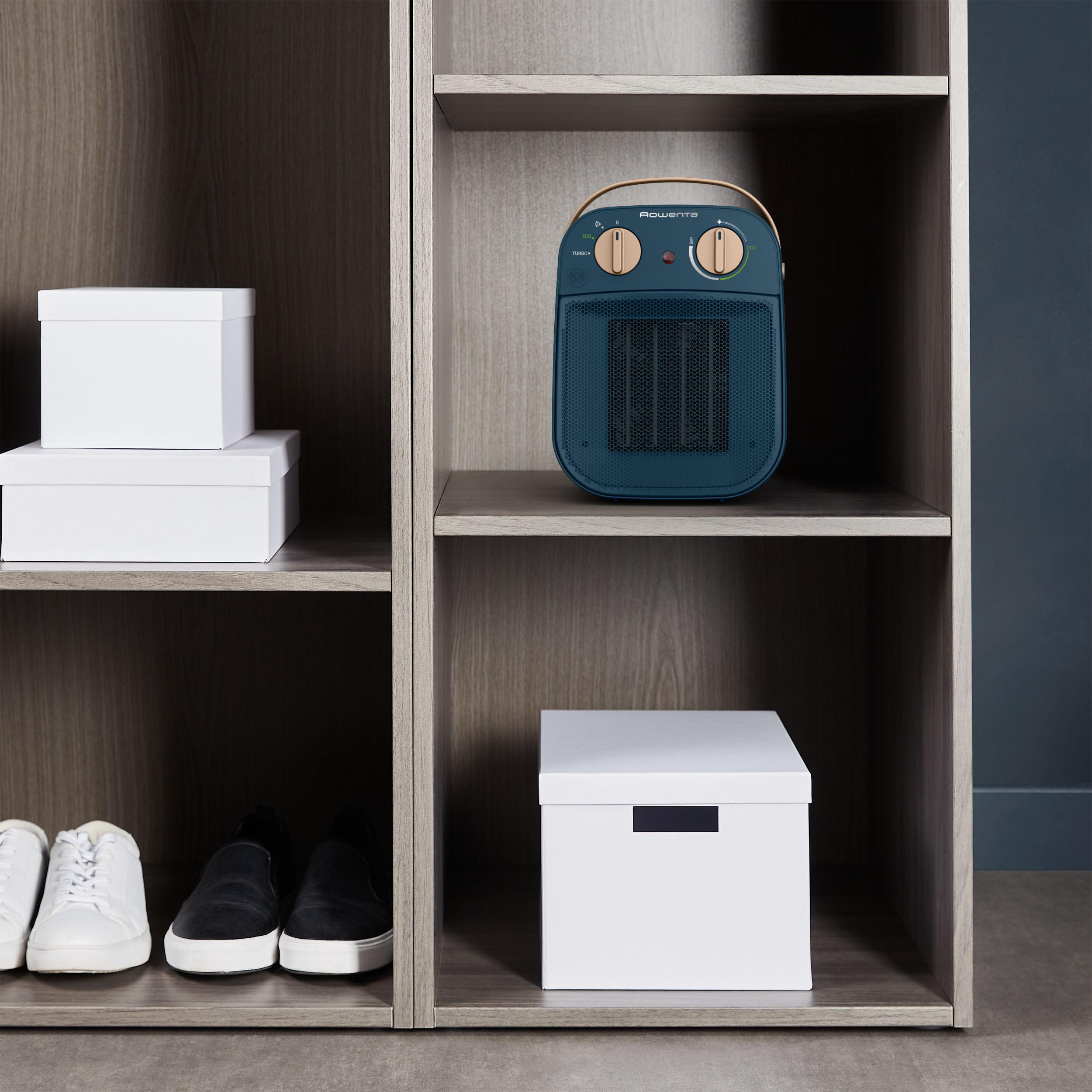 Holzschrank mit einem Heizgerät im mittleren Regal und weißen Boxen an den Seiten.