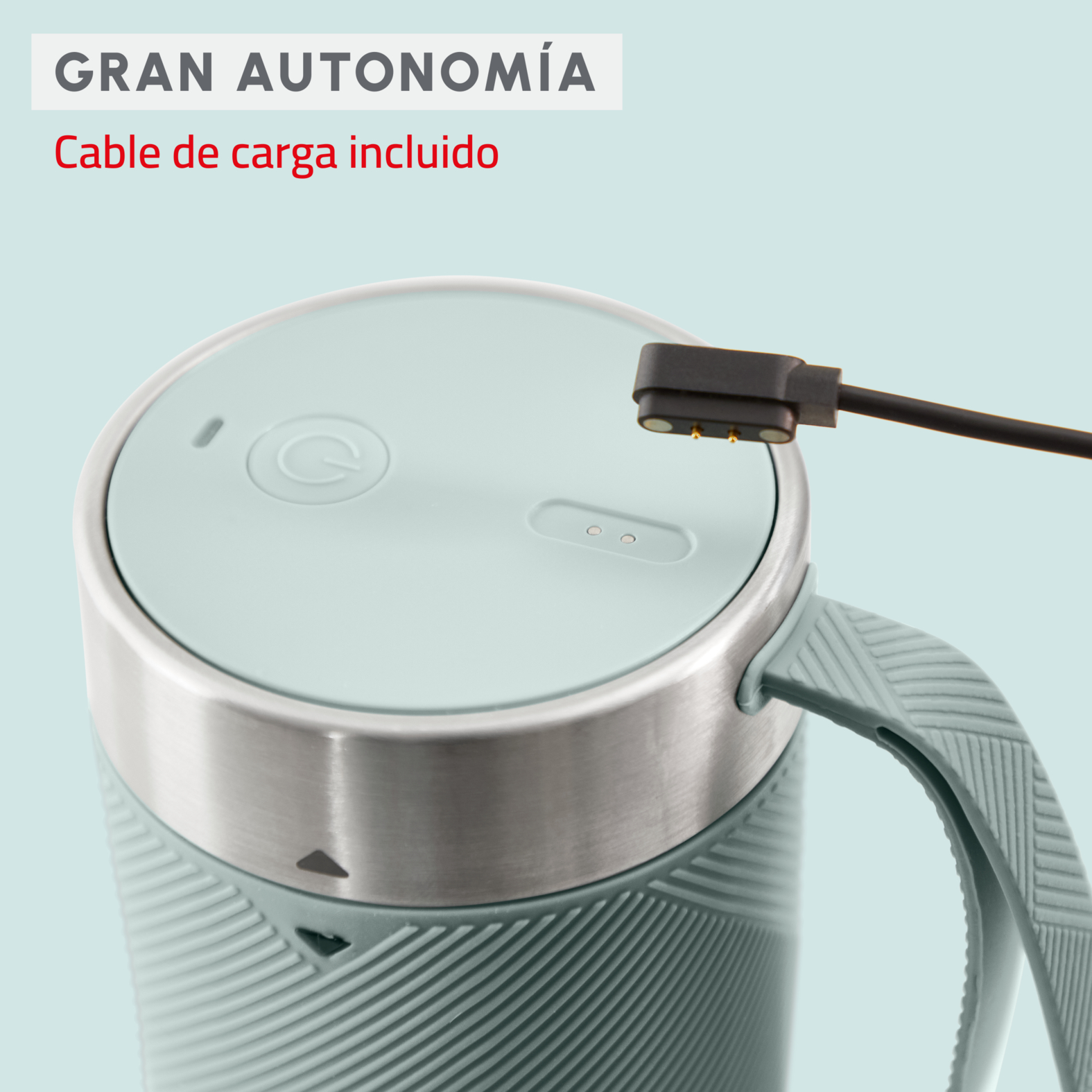 Primer plano de un altavoz inteligente turquesa con cable de carga y anillo plateado.