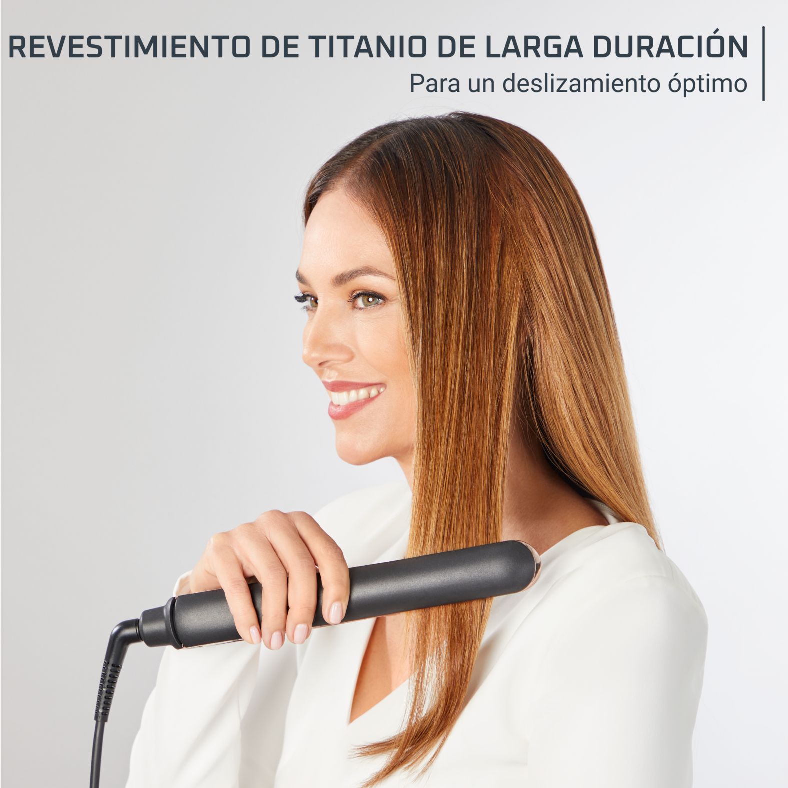 Mujer usando una plancha. El texto arriba dice: 'RECUBRIMIENTO DE TITANIO DE LARGA DURACIÓN'. Sonríe.