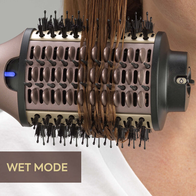 Capelli avvolti attorno a una spazzola per lo styling rotante con manico nero e marrone.