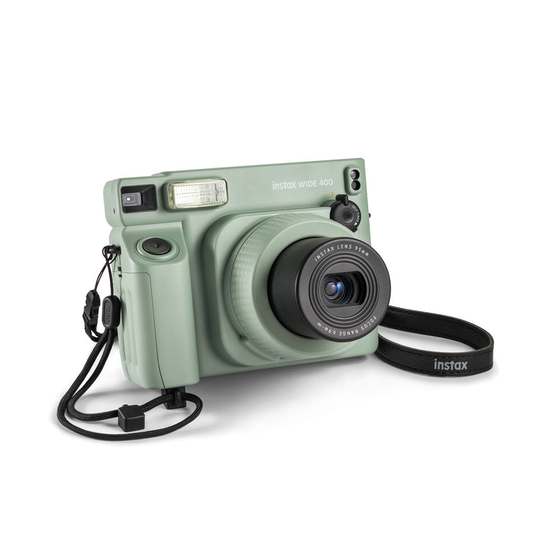 Siyah kayış ve lensli, nane yeşili bir Instax Wide 400 kamera.