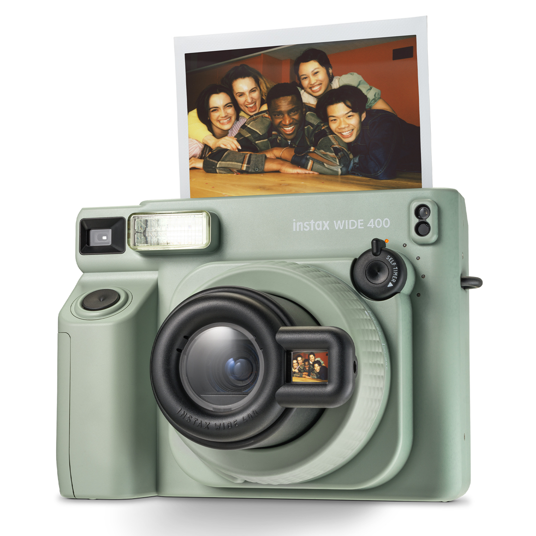 Üzerinde insanların fotoğrafı olan yeşil instax WIDE 400 fotoğraf makinesi. Kameranın bir merceği var.