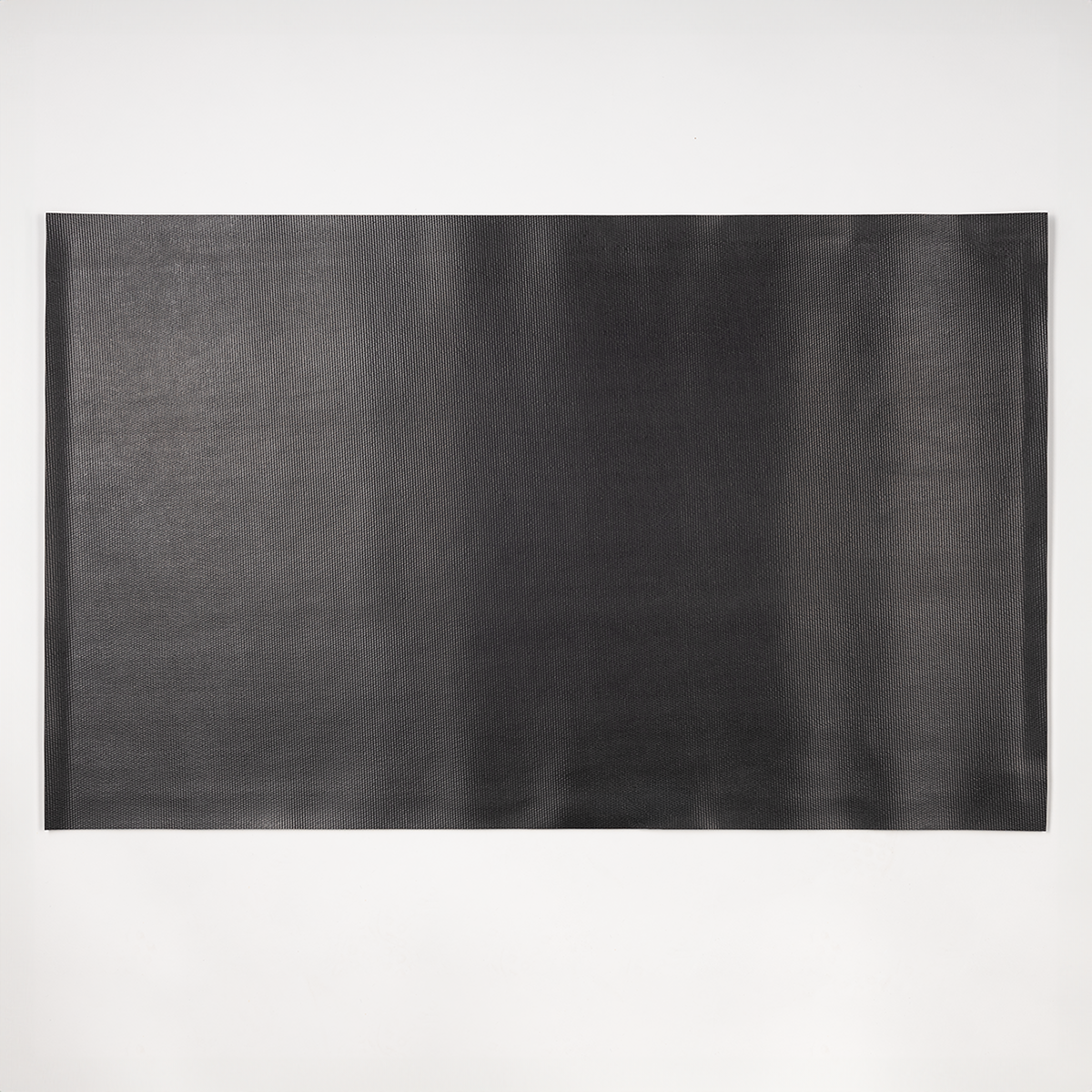 Eine schwarze rechteckige Matte auf weißer Oberfläche.