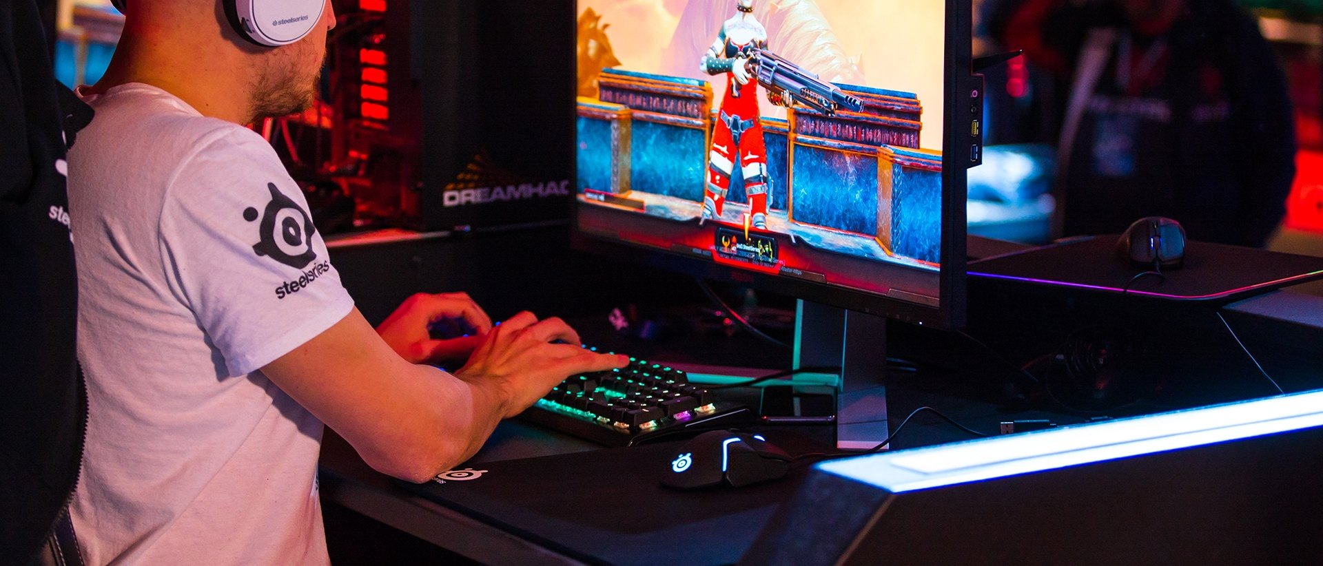 Gamer, der ein Spiel am Computer mit Tastatur und Maus spielt.