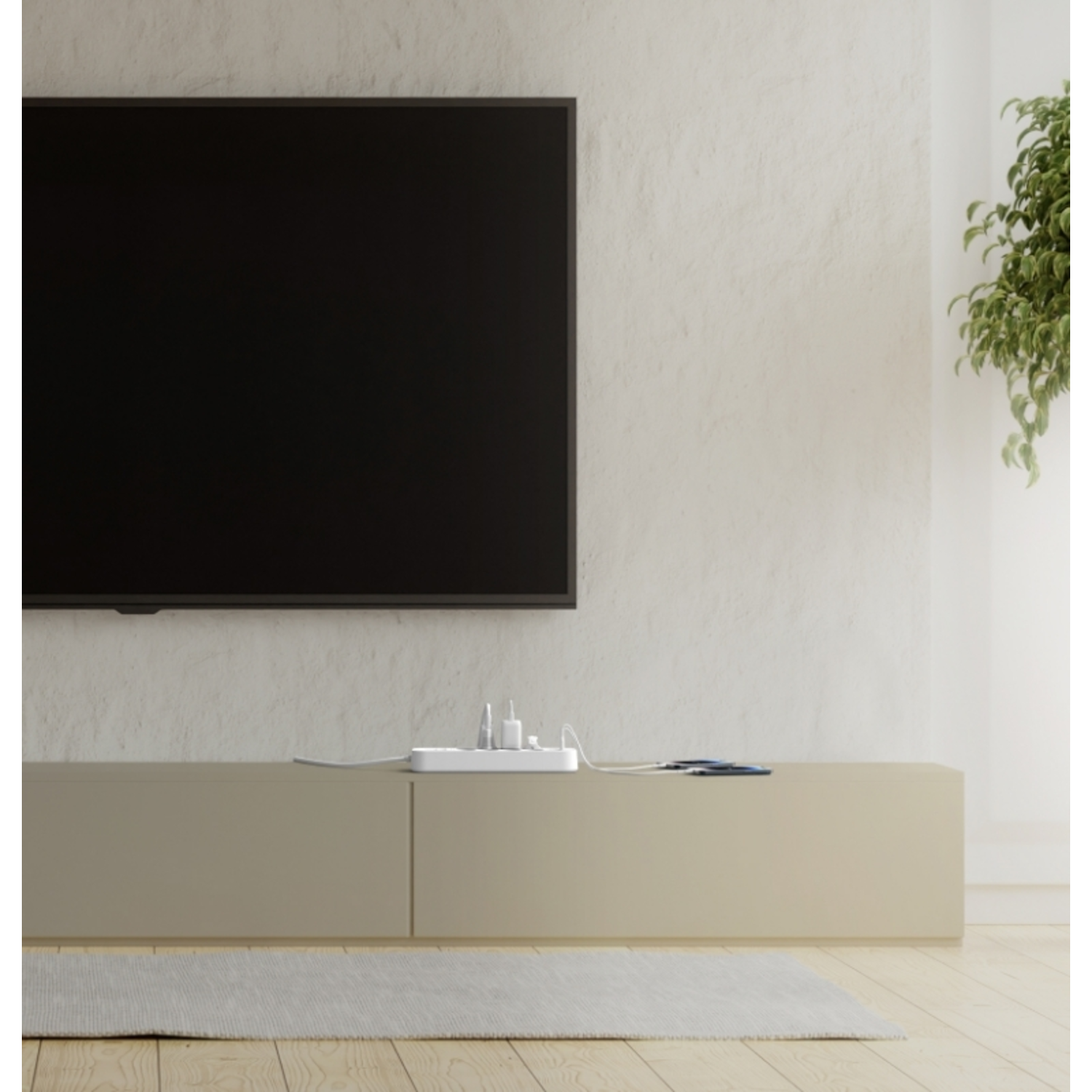 Een woonkamer met een tv op een beige kast. Er ligt een stekkerdoos op de kast.
