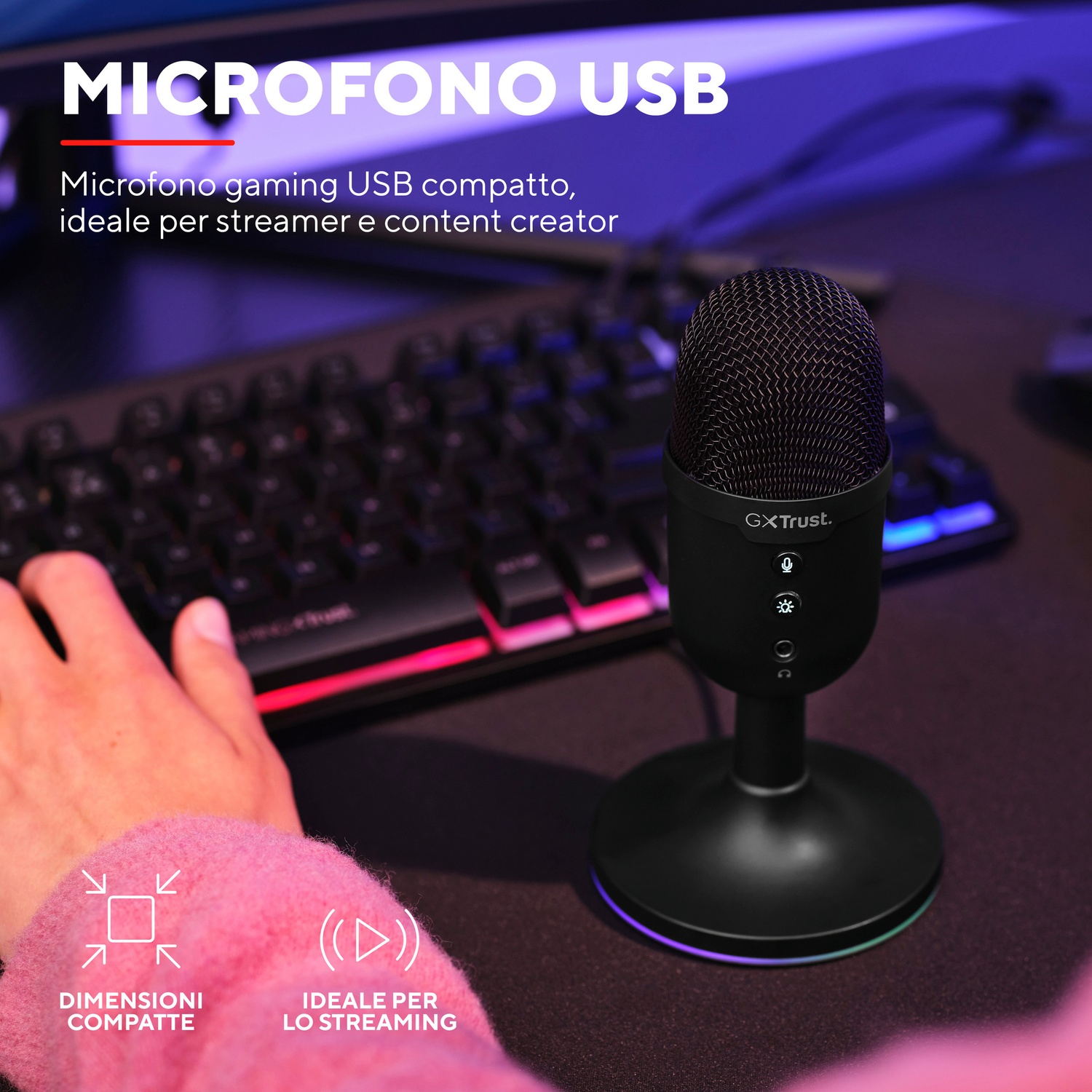 Un microfono USB nero su un supporto, con una tastiera sullo sfondo.
