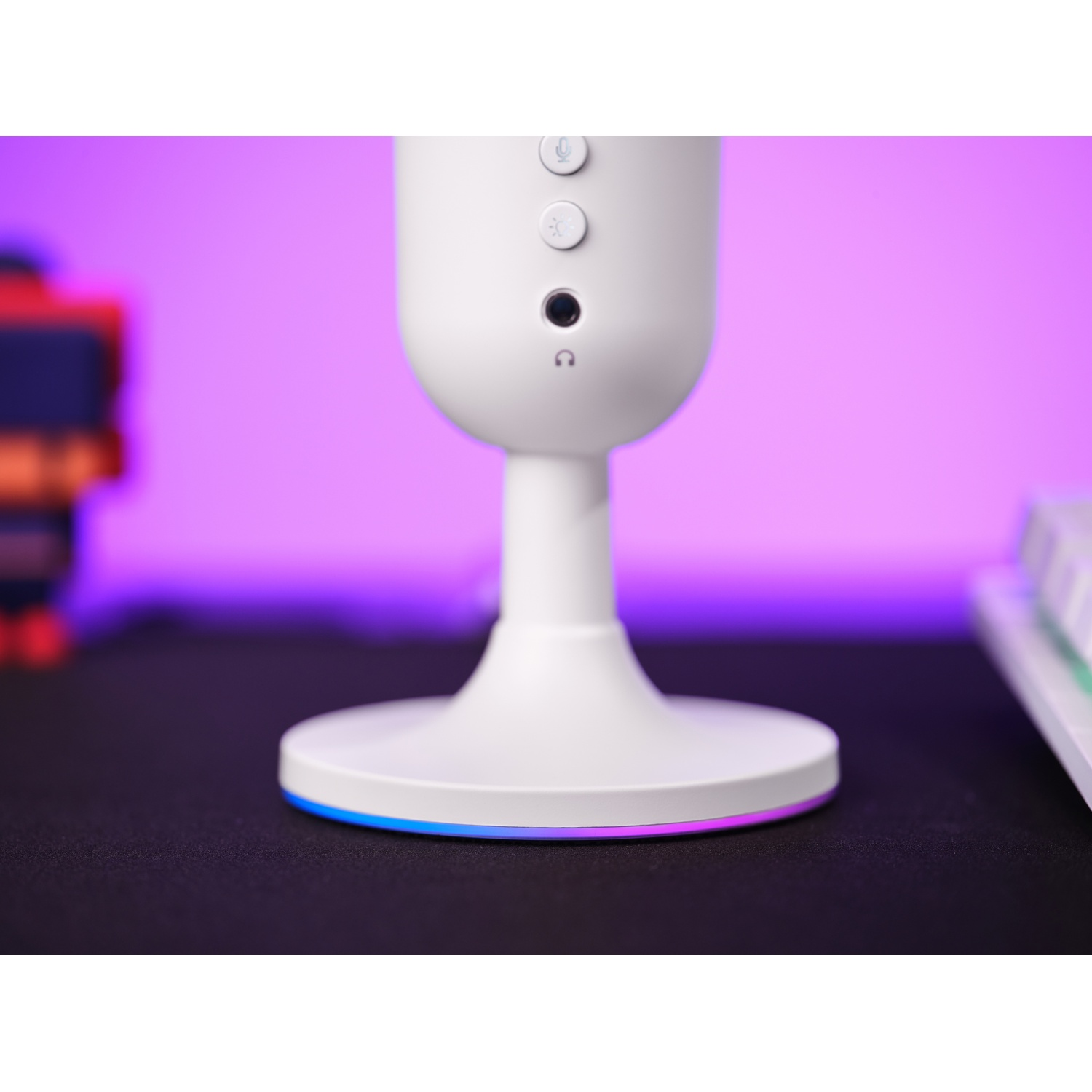Microfono bianco con pulsanti, base con striscia luminosa colorata su superficie nera.