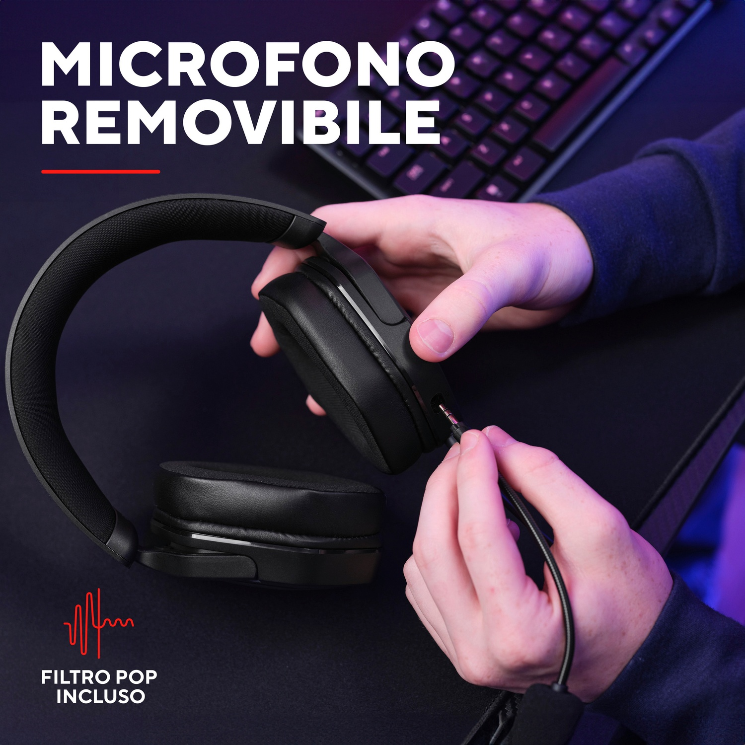 Una persona sta collegando un cavo del microfono a un auricolare nero. L'auricolare è su una scrivania.
