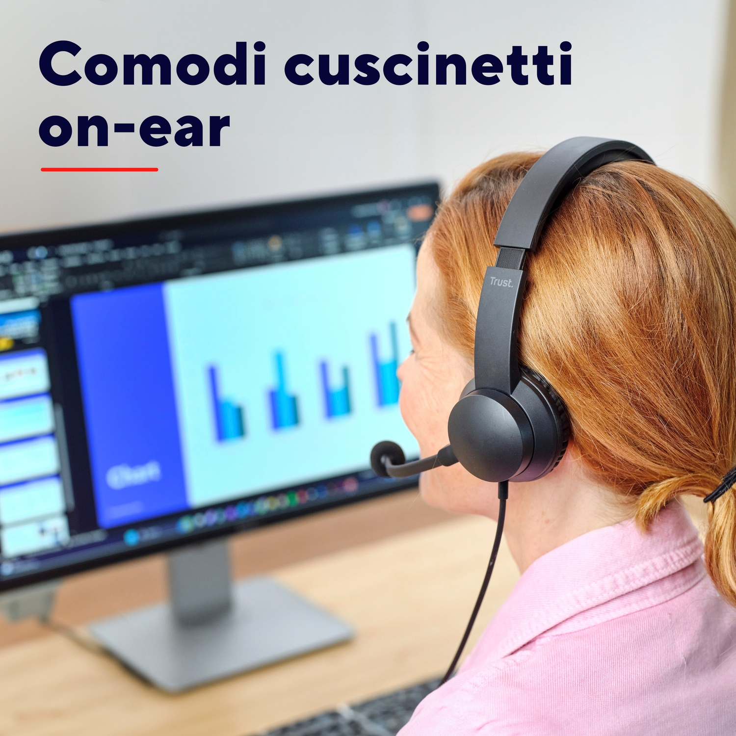 Una donna con cuffie nere davanti a un computer.