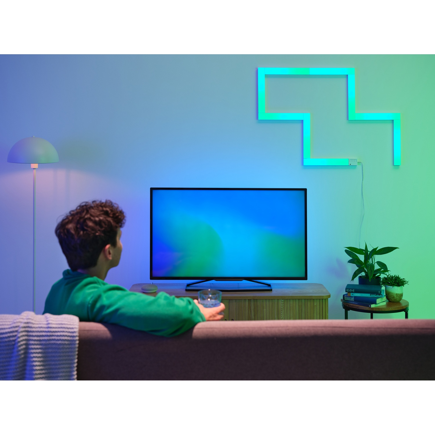 Una persona guarda la TV con un'applique in una stanza.