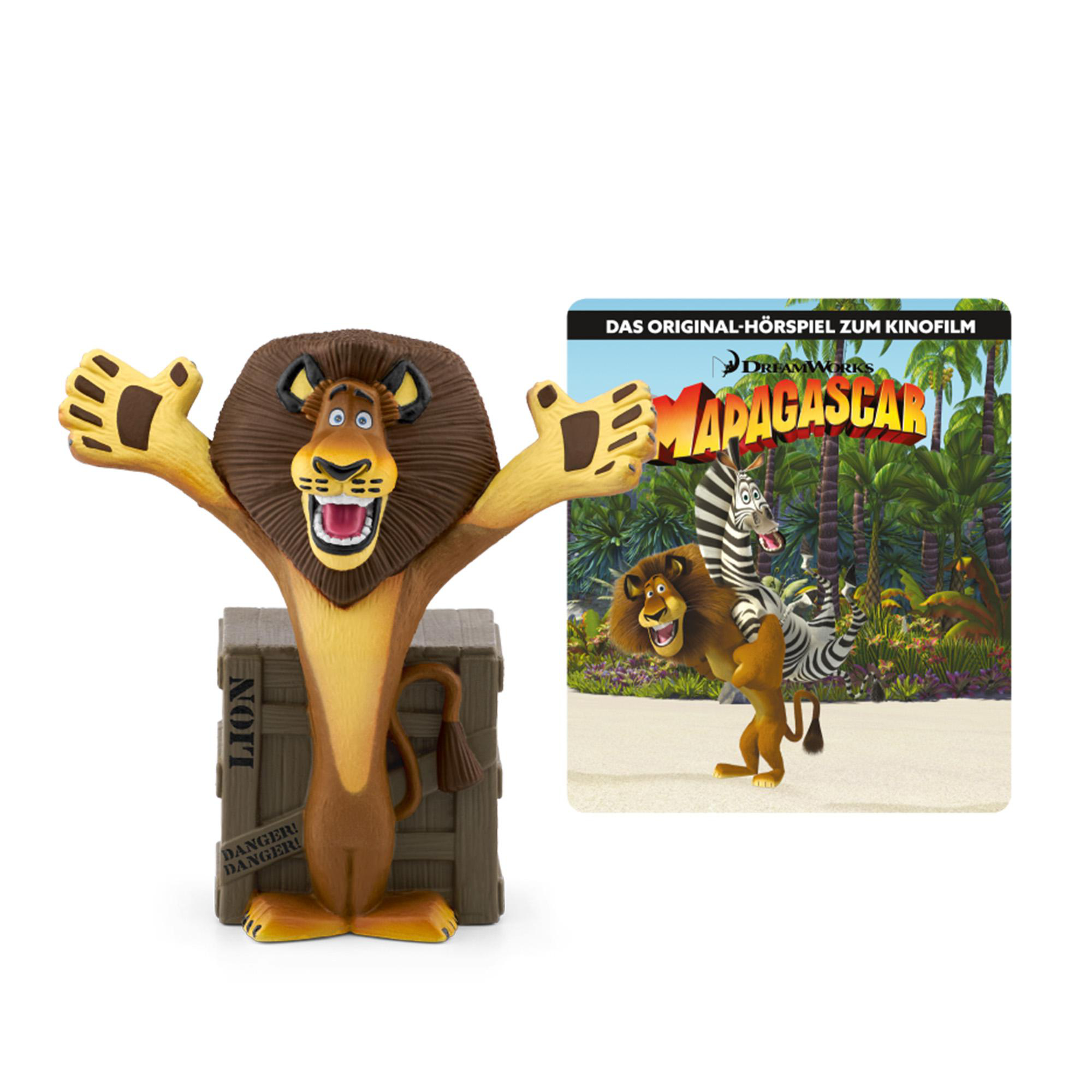 Löwenspielzeug neben Madagascar-Filmanzeige.