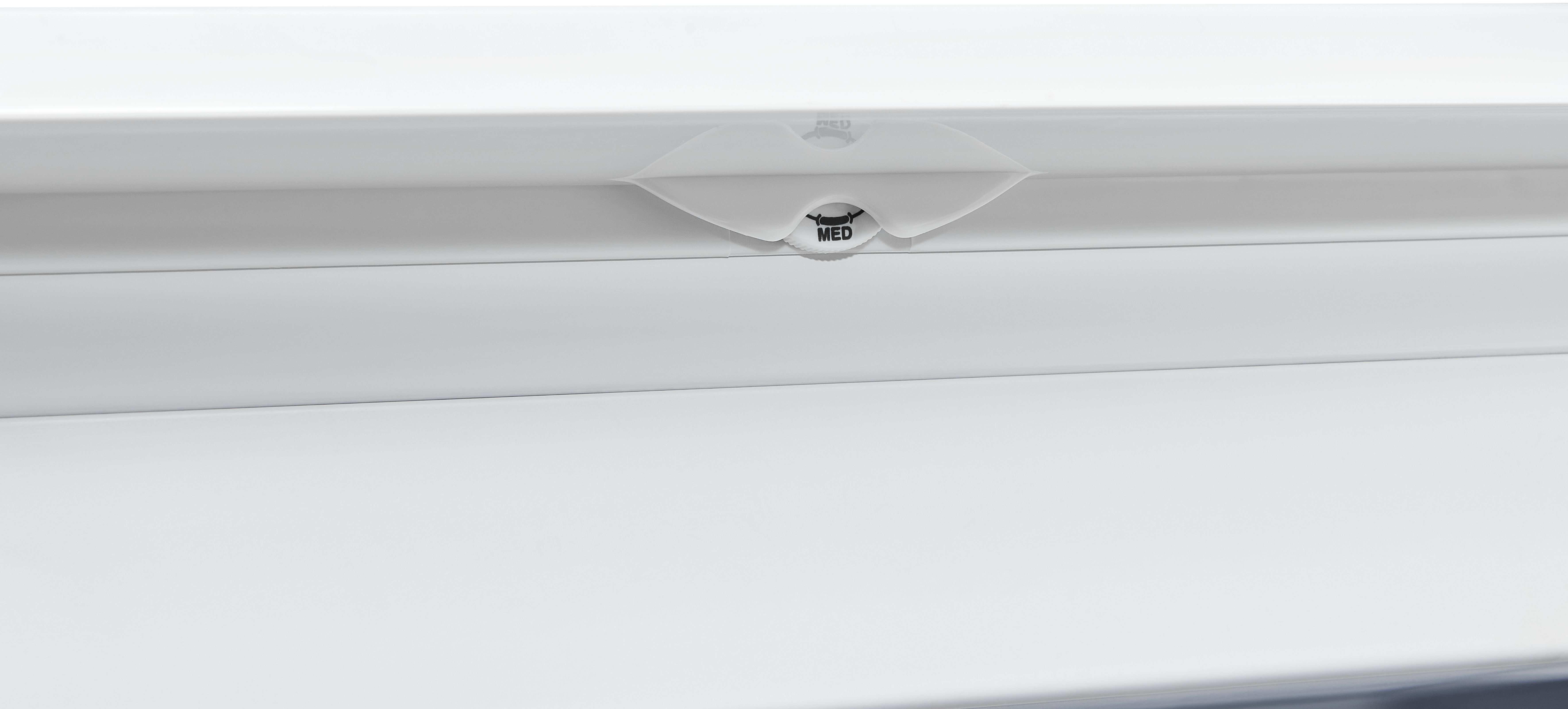 Un objet blanc avec un cadran étiqueté MED est montré. Il a une surface blanche.