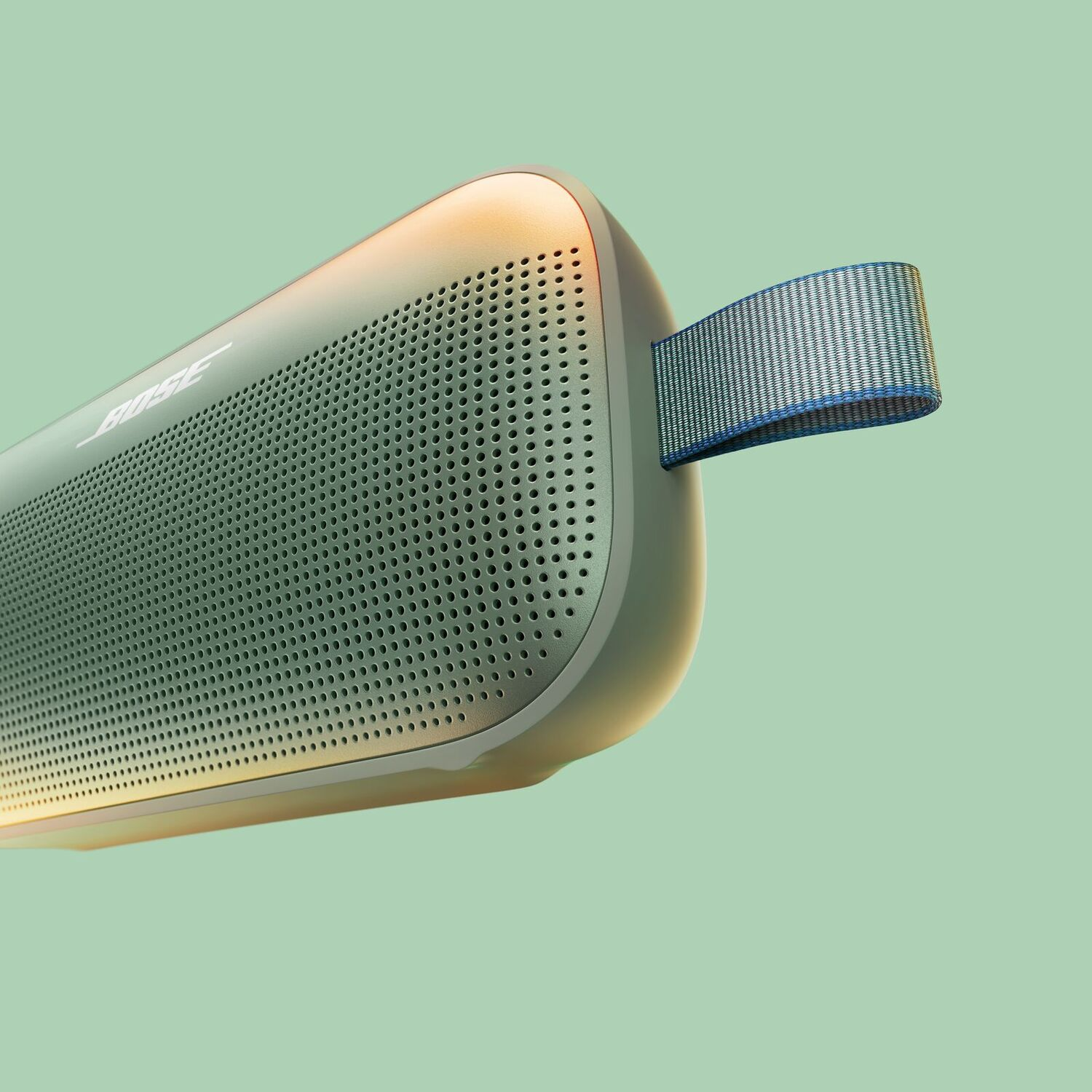 Een close-up van een groene luidspreker met het woord BOSE erop. De achtergrond is lichtgroen.