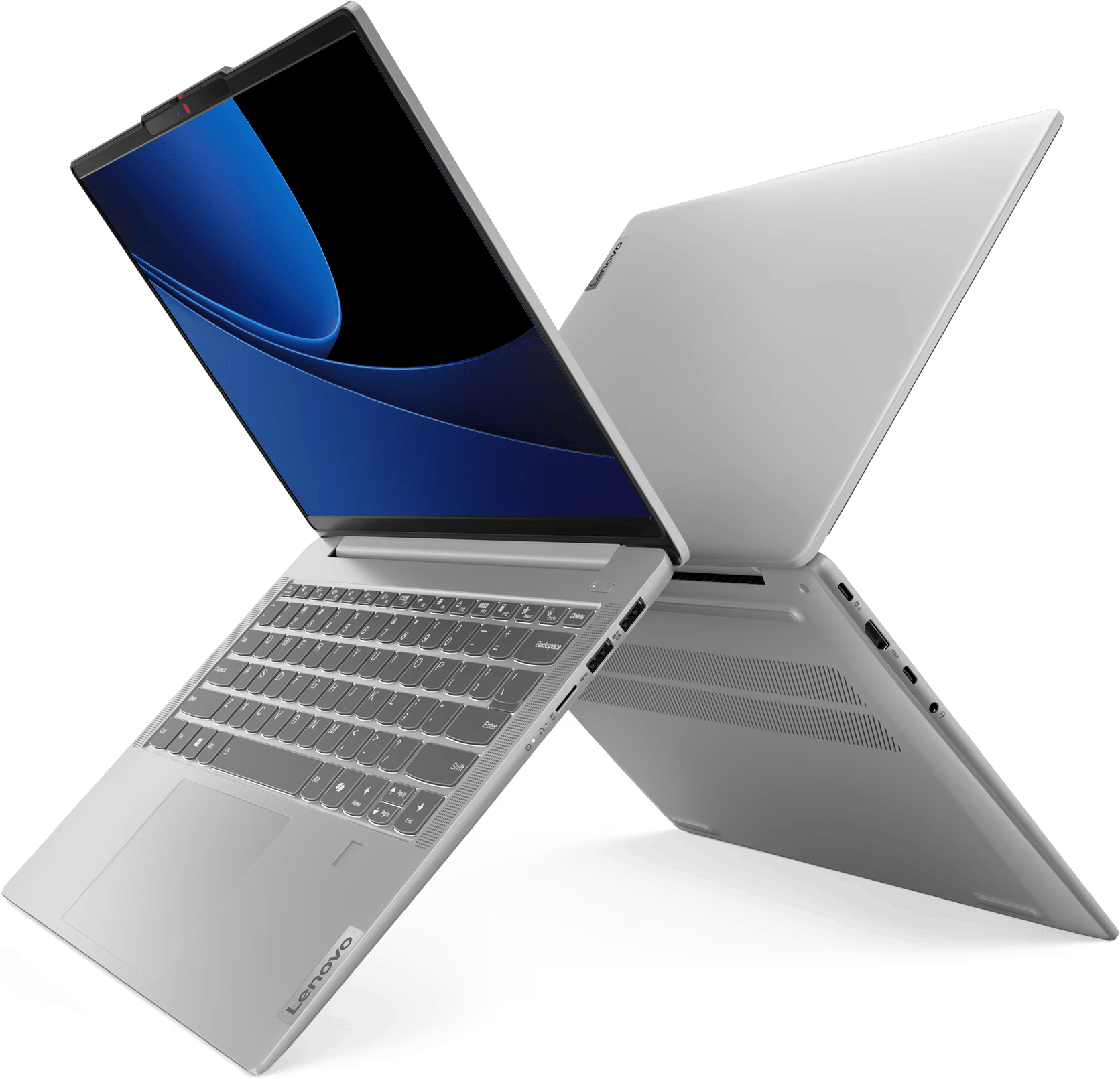 Laptop nyitott képernyővel, ezüst testtel, fekete háttéren. A laptop meg van döntve.