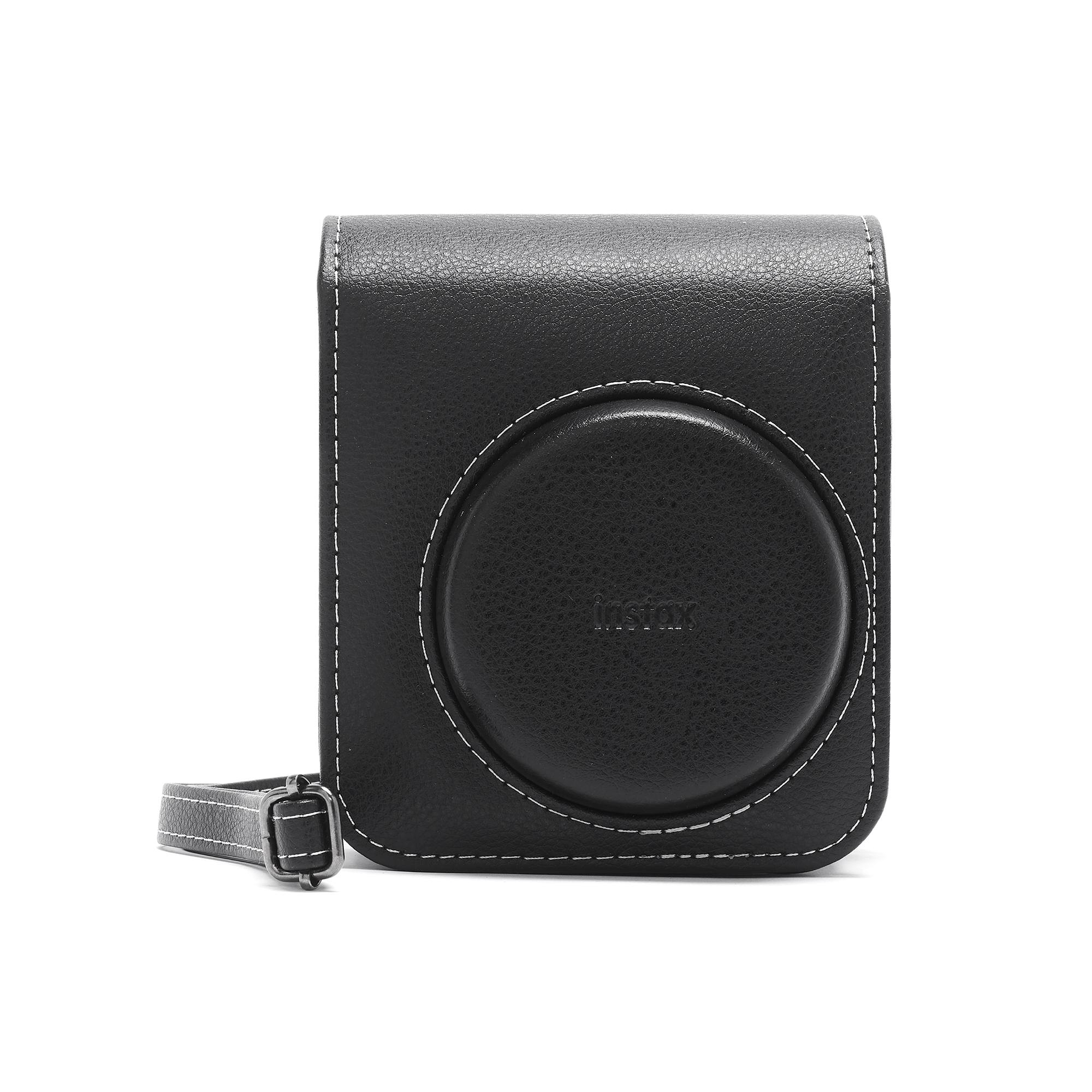 Schwarze Leder-Kameratasche mit Instax-Logo. Weiße Nähte und ein Trageriemen. Weißer Hintergrund.