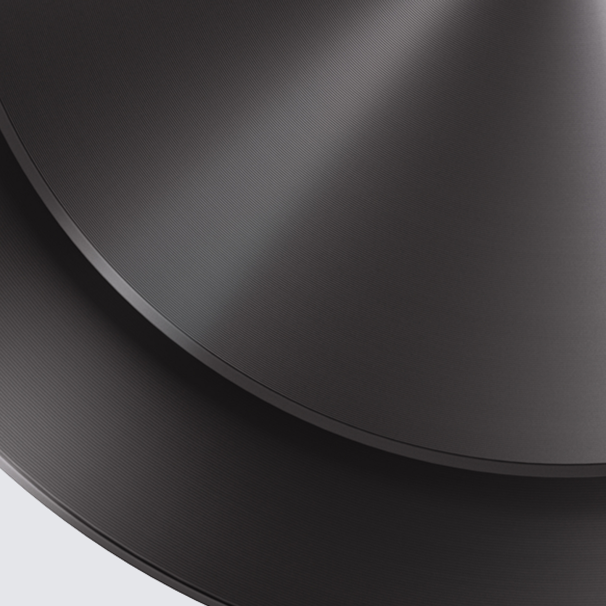 Primer plano de un objeto metálico gris oscuro con surcos. Superficie con líneas finas y paralelas.