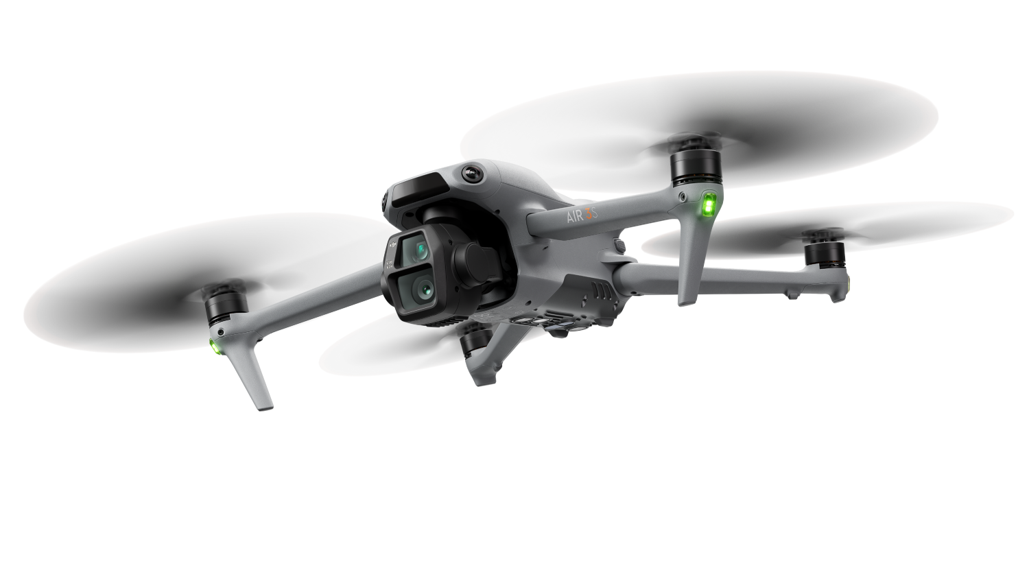 Se muestra un dron gris con cuatro hélices. El dron está sobre un fondo negro.