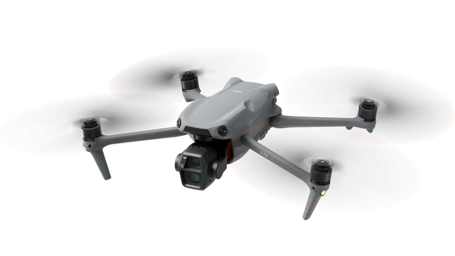 Un dron gris con cuatro hélices y una cámara. El dron está sobre un fondo negro.