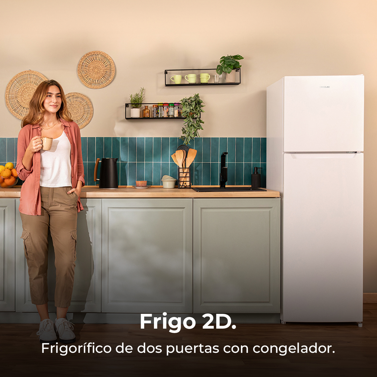 Una mujer en una cocina junto a un refrigerador blanco, sosteniendo una taza.