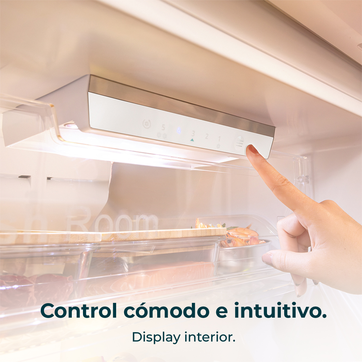 Mano tocando el panel de control del refrigerador. Pantalla interior visible.