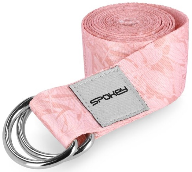 Różowy pasek do jogi ze wzorem kwiatowym, zwinięty i ze srebrnymi kółkami.